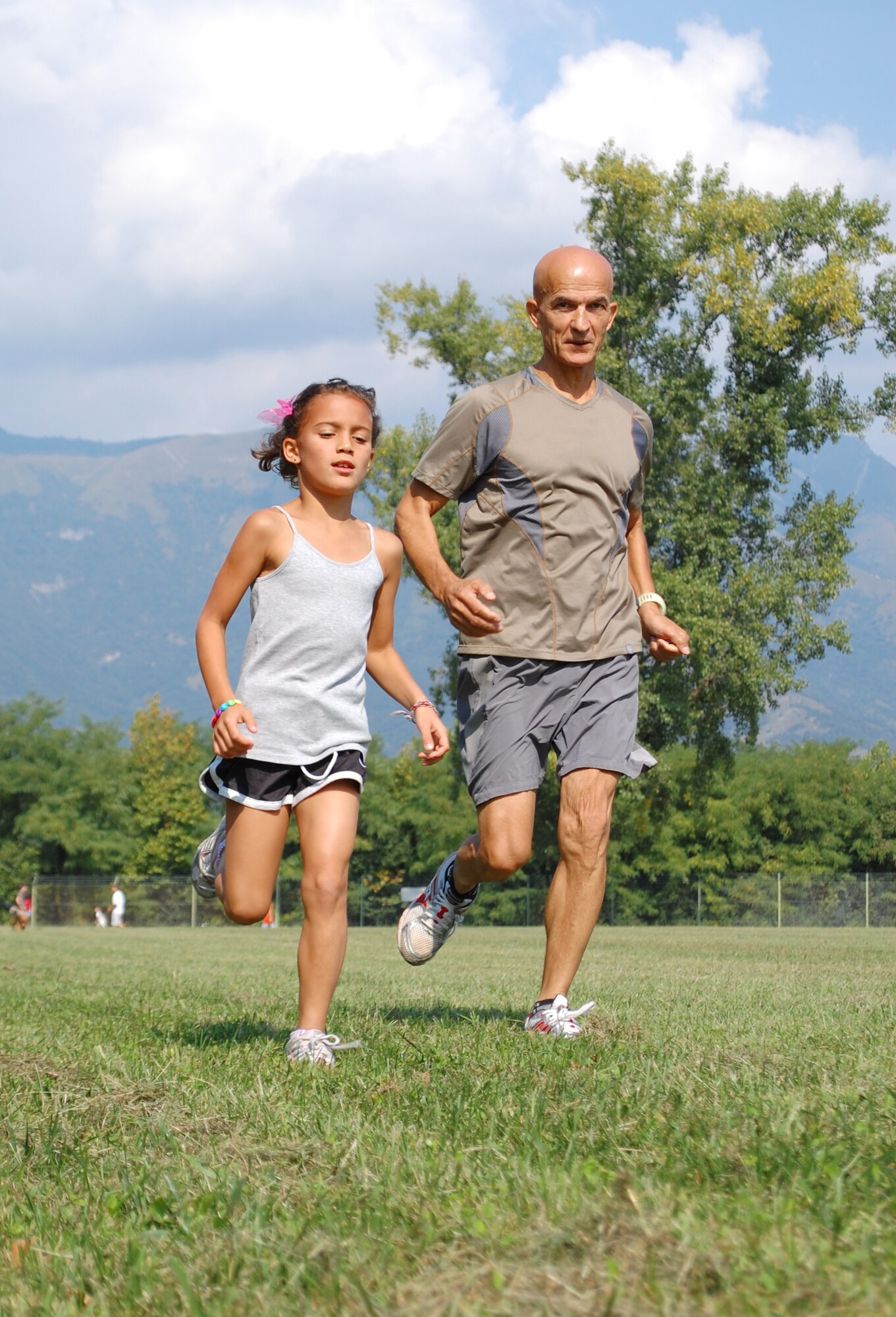 Huseyin Kara runs alongside his daughter, Emma, as she competes in the one-mile children's fun run Sept. 13, 2009 in Area D located outside Aviano Air Base in the town of Aviano, Italy. The children's race was part of the Third Annual Aviano Marathon celebration. (U.S. Air Force photo/Staff Sgt. Lindsey Maurice)