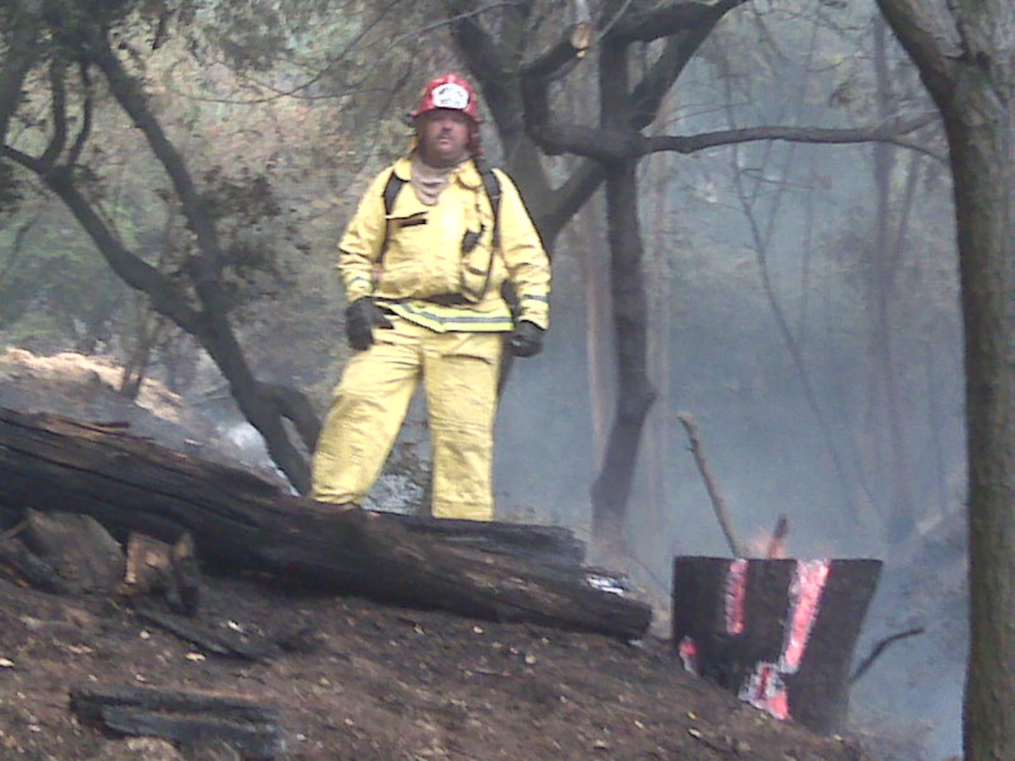 Fire captain Frank Hanson standing in front of a house that their strike team was able to save. (U.S. Air Force photo)