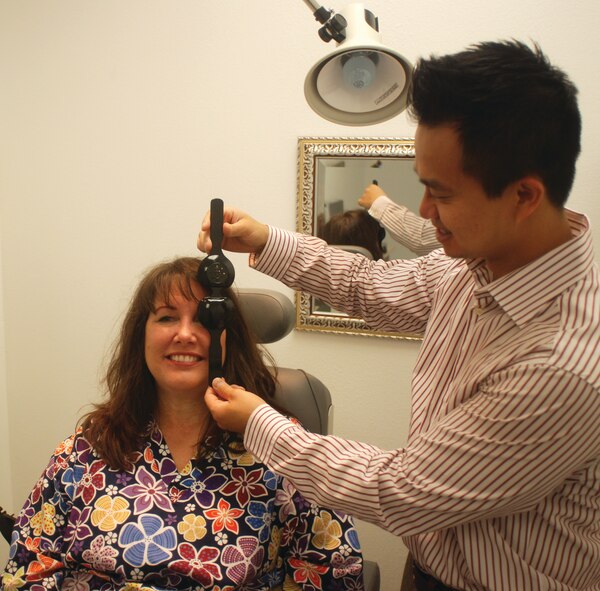 Dr. Philip Quach, an Optometrist, uses his technician, Kathy Marchetti, to demonstrate the use of an occluder, used for checking a patient’s visual acuity. Quach recommends getting an eye examination every year. Exams are free for
TRIWEST members. (U.S. Air Force photo by Megan Just)