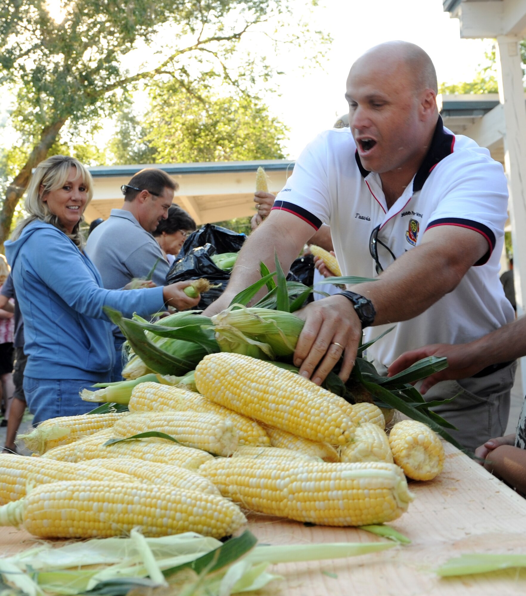 MOUNTAIN HOME AIR FORCE BASE, Idaho -- Lt. Col. Travis Condon, 366th Logistics Readiness Squadron commander, passes corn down the table during the 49th annual Air Force Appreciation Day corn shucking competition Sept. 11 in downtown Mountain Home. The year's festivities also included a fun run Sept. 11 and ended with the parade and free barbecue Sept. 12. AFAD began in 1962 as a way for the Mountain Home Chamber of Commerce to express their gratitude for the economic benefits the Air Force brought to the area and a way to encourage neighborly growth. (U.S. Air Force photo by Airman 1st Class Debbie Lockhart)