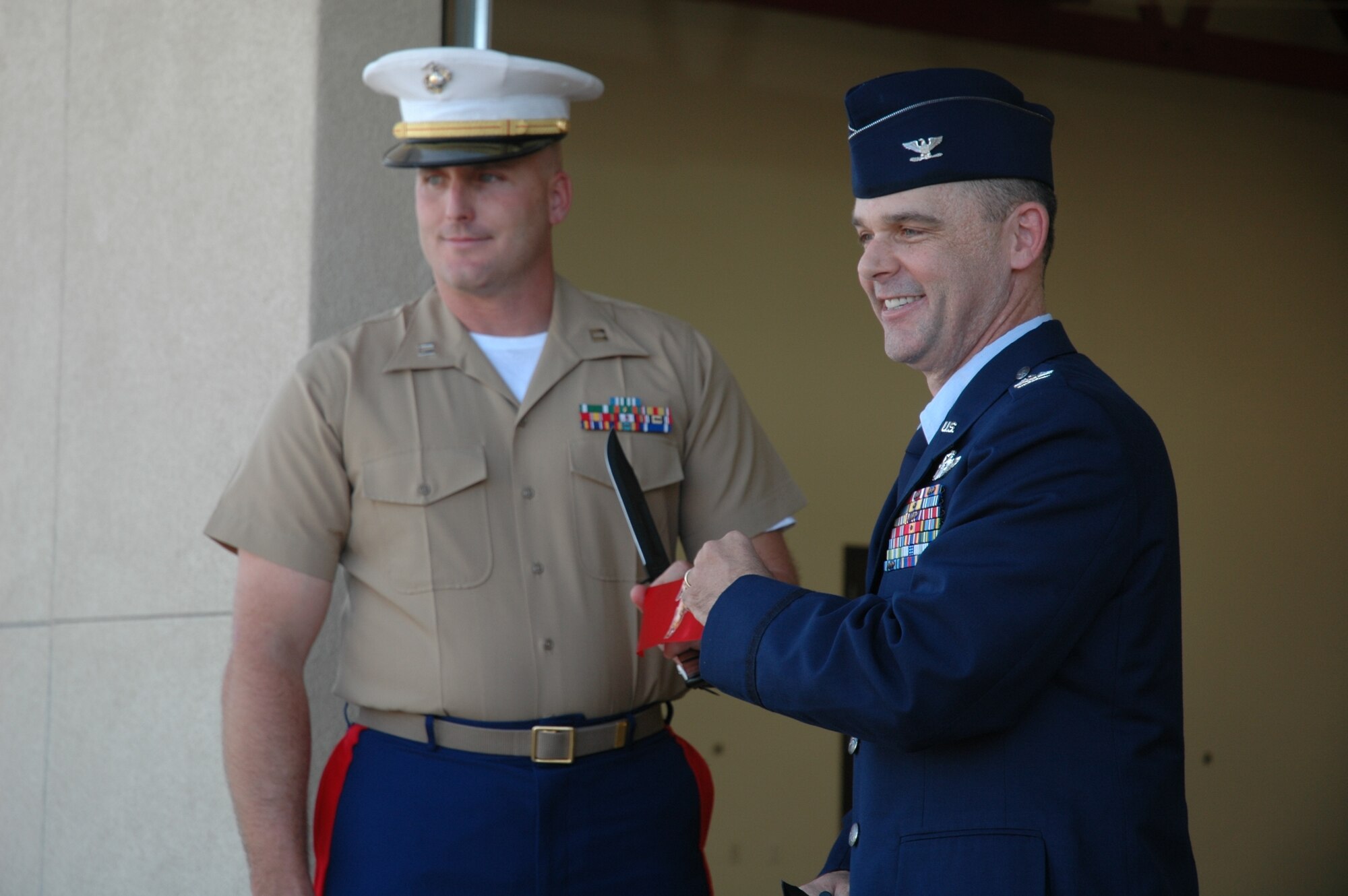 Marine Corps Capt. Nathan Bowlin cuts a ribbon Sept. 12 with the help of Col. Jeffrey Weed, 56th Fighter Wing vice commander, during a ribbon cutting ceremony for the new home of the 6th Engineer Support Battalion Bulk Fuel Charlie Company. (U.S. Air Force photo/Senior Airman Andre Bowser)