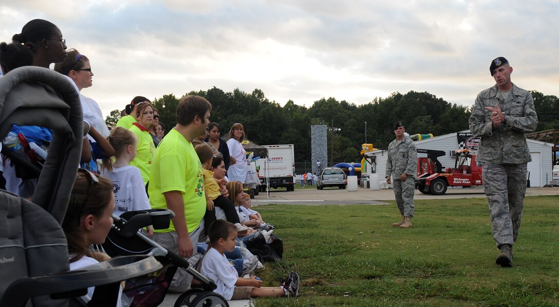 LANGLEY AIR FORCE BASE, Va. -- Tech. Sgt. Ronald Denisi, 1st Security Forces Squadron kennel master, explains the capabilities of military working dogs to the crowd gathered for Freedom Walk at Langley Speedway Sept. 11. Freedom Walk was held in remembrance of those lost during 9/11 terrorist attacks and to honor our military members and first responders.  (U.S. Air Force photo/Senior Airman Zachary Wolf)