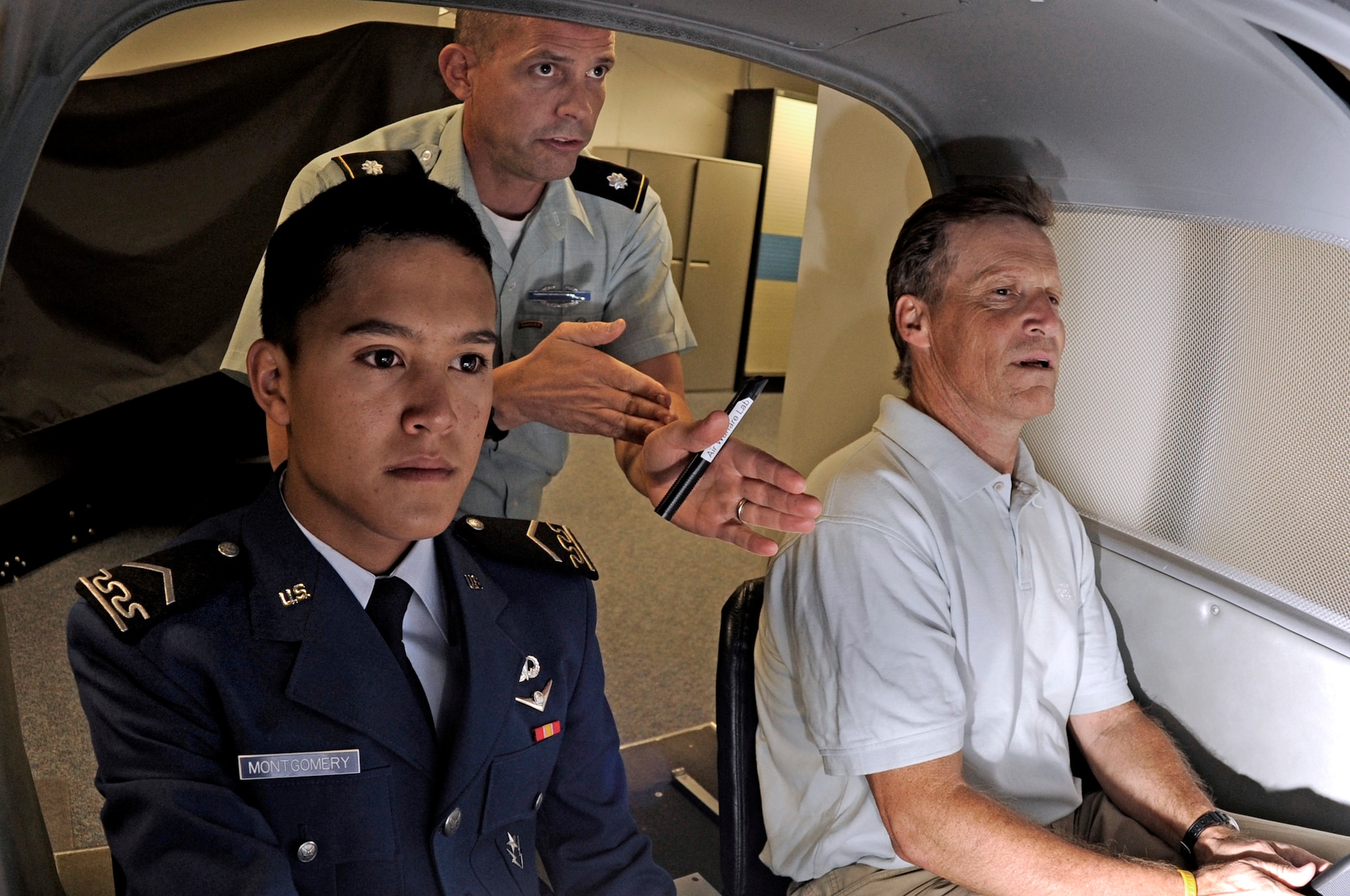 Jack Montgomery receives instruction from Army Lt. Col. David Christensen while piloting a flight simulator in Fairchild Hall Sept. 4, 2009, as part of Parents' Weekend. Seated in the co-pilot's chair is Mr. Montgomery's son, Cadet 3rd Class Tate Montgomery. (U.S. Air Force photo/Mike Kaplan)