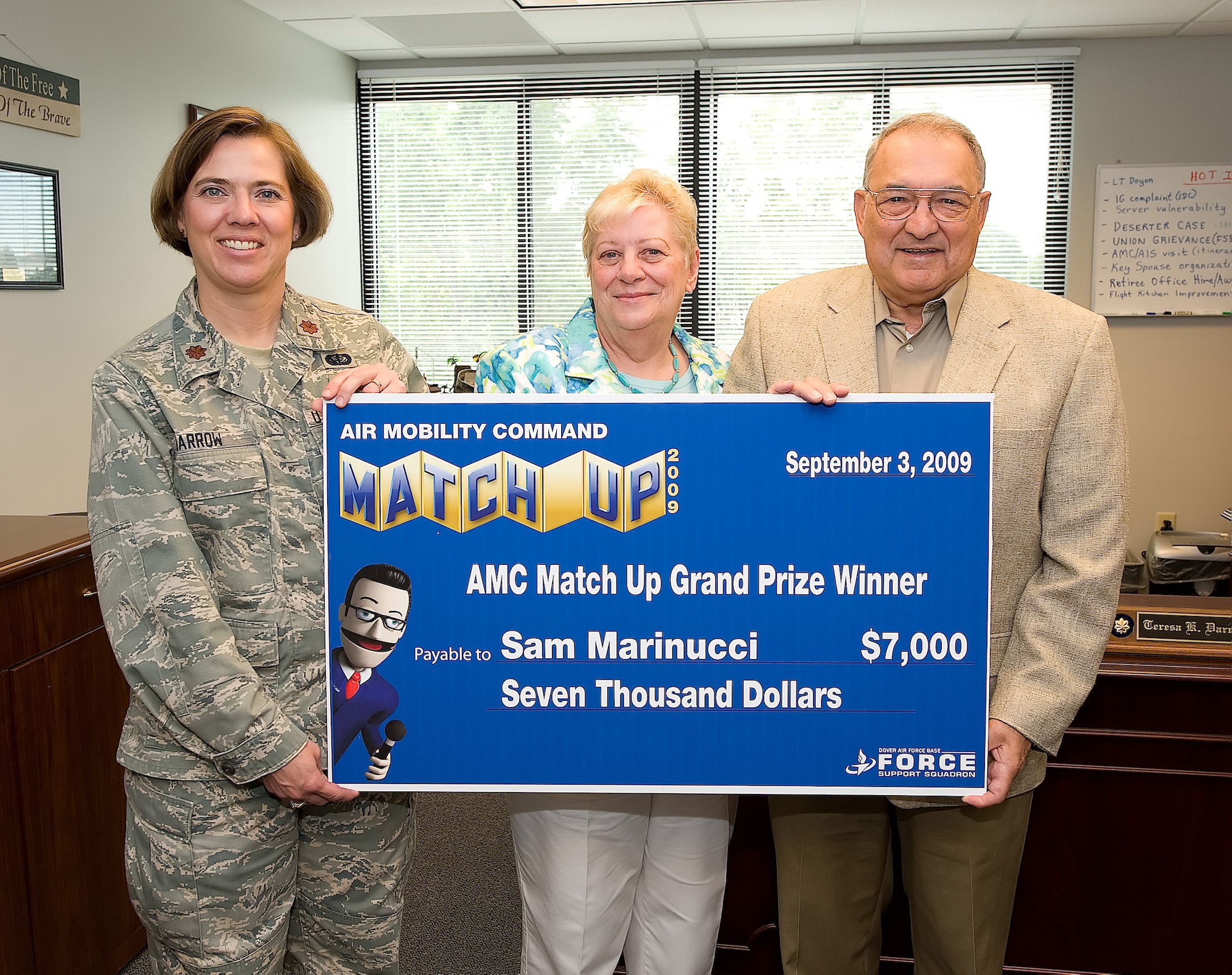 (Right) Sam Marinucci, retired technical sergeant, with his wife Jan Marinucci receives a $7,000 grand prize from Maj. Teresa Darrow, 436th Force Support Squadron commander, from the Air Mobility Command MatchUp game. Mr. Marinucci retired from Dover Air Force Base after 22 years of service in the United States Air Force. (U.S. Air Force photo/Jason Minto)