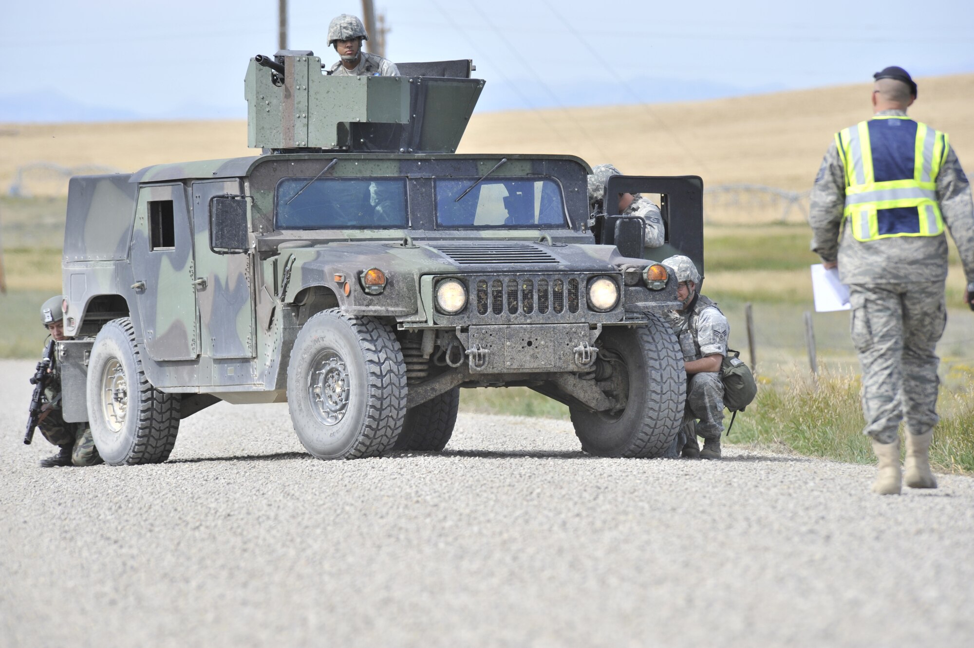 Missile Security Forces members get into position during the denial exercise while a 20th Air Force Combat Capability Evaluator walks towards them to observe. (U.S. Air Force photo/John Turner)