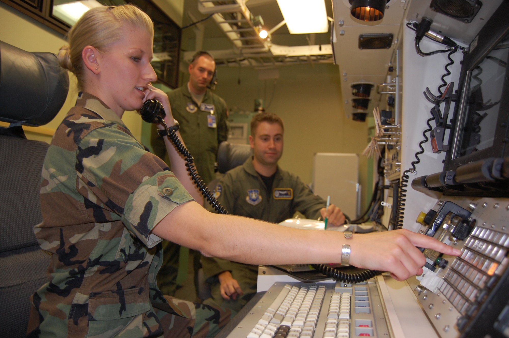 Capt. Dan Bunch, 20th Air Force Combat Capability Evaluation Team, evaluates the performance of Capt. Adam Brandao and 1st Lt. Ella Kassha, 341st Operations Support Squadron in the missile procedure trainer as part of the evaluation. (U.S. Air Force photo/Tech. Sgt. Marcus McDonald)