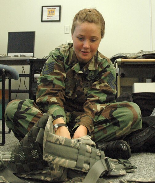 MCCHORD AIR FORCE BASE, Wash.- Tech. Sgt. Vanessa Walsh, a Security Forces Reservist with the 446th Security Forces Squadron here, attaches a pouch and other accessories to her utility vest in the 446th SFS training room here, Sept. 12. Sergeant Walsh, a traditional Reservist, teaches the sixth grade in the Bethel Wash. School District. (U.S. Air Force photo/Staff Sgt. Nicole Celestine).