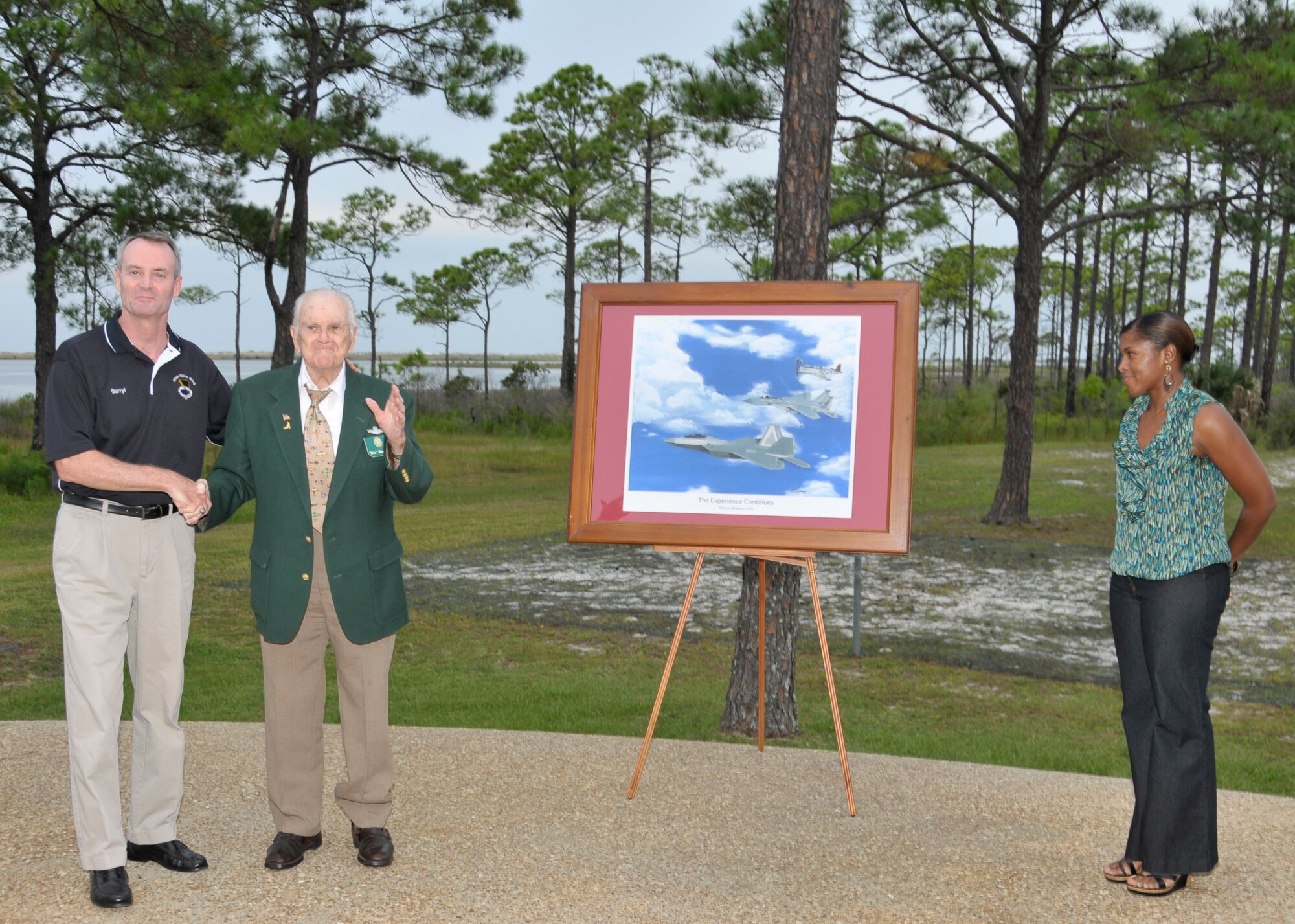 Brigadier General Darryl Roberson, Retired Lt. Col. Raymond MacKinnon and Captain Adrienne Beamon unveil "The Experience Continues" painting Sept. 11 at the Heritage Club.