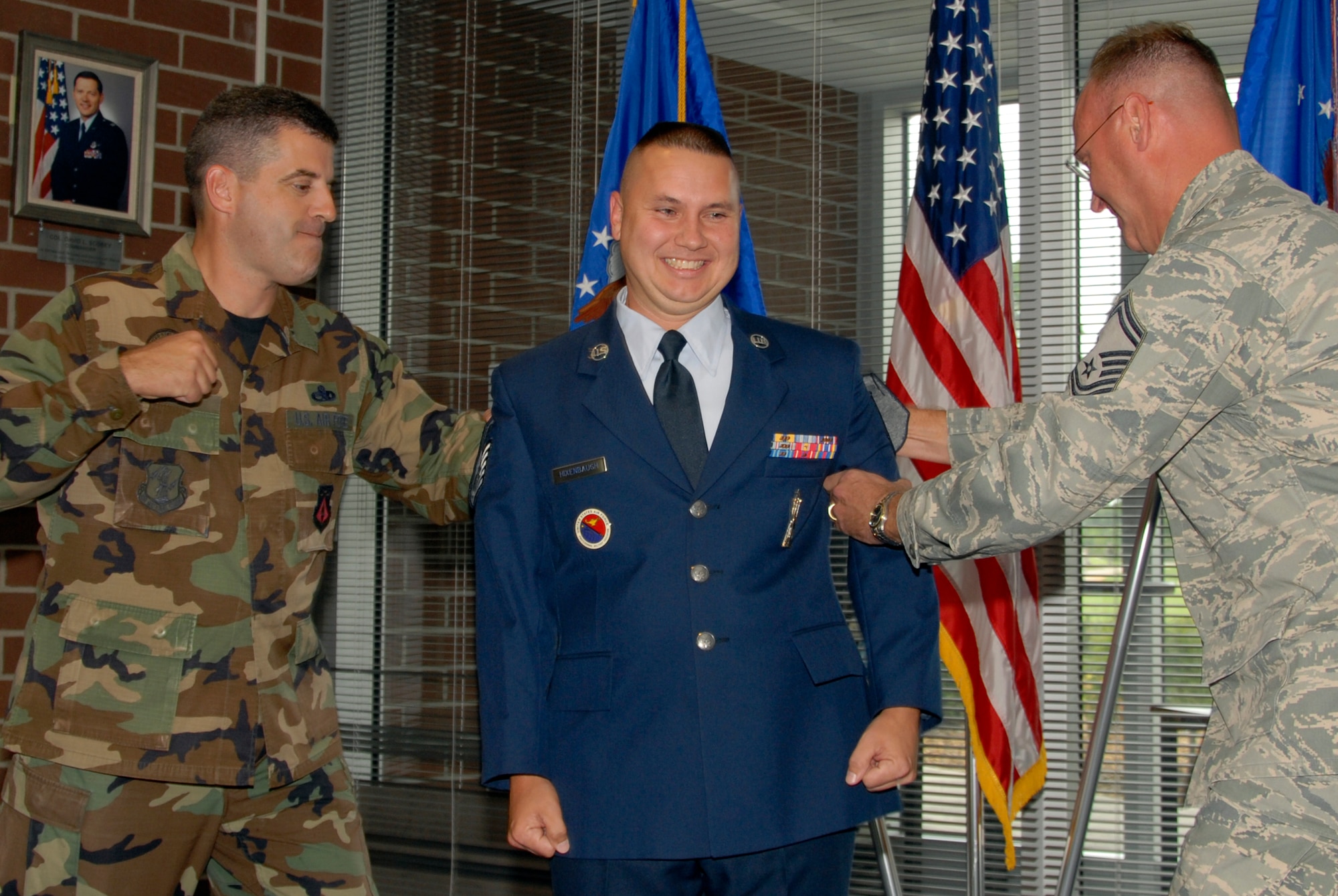 McGHEE TYSON AIR NATIONAL GUARD BASE, Tenn. -- Master Sgt. Francis M. Linardo, left, and Senior Master Sgt. Timothy J. Kumes, right, tack master sergeant stripes on Tech. Sgt. David W. Hixenbaugh during his promotion ceremony in Patriot Hall at The I.G. Brown Air National Guard Training and Education Center on Aug. 28.  Hixenbaugh leads the Paul H. Lankford Enlisted Professional Military Education Center's satellite program.  (U.S. Air Force photo by Master Sgt. Kurt Skoglund)