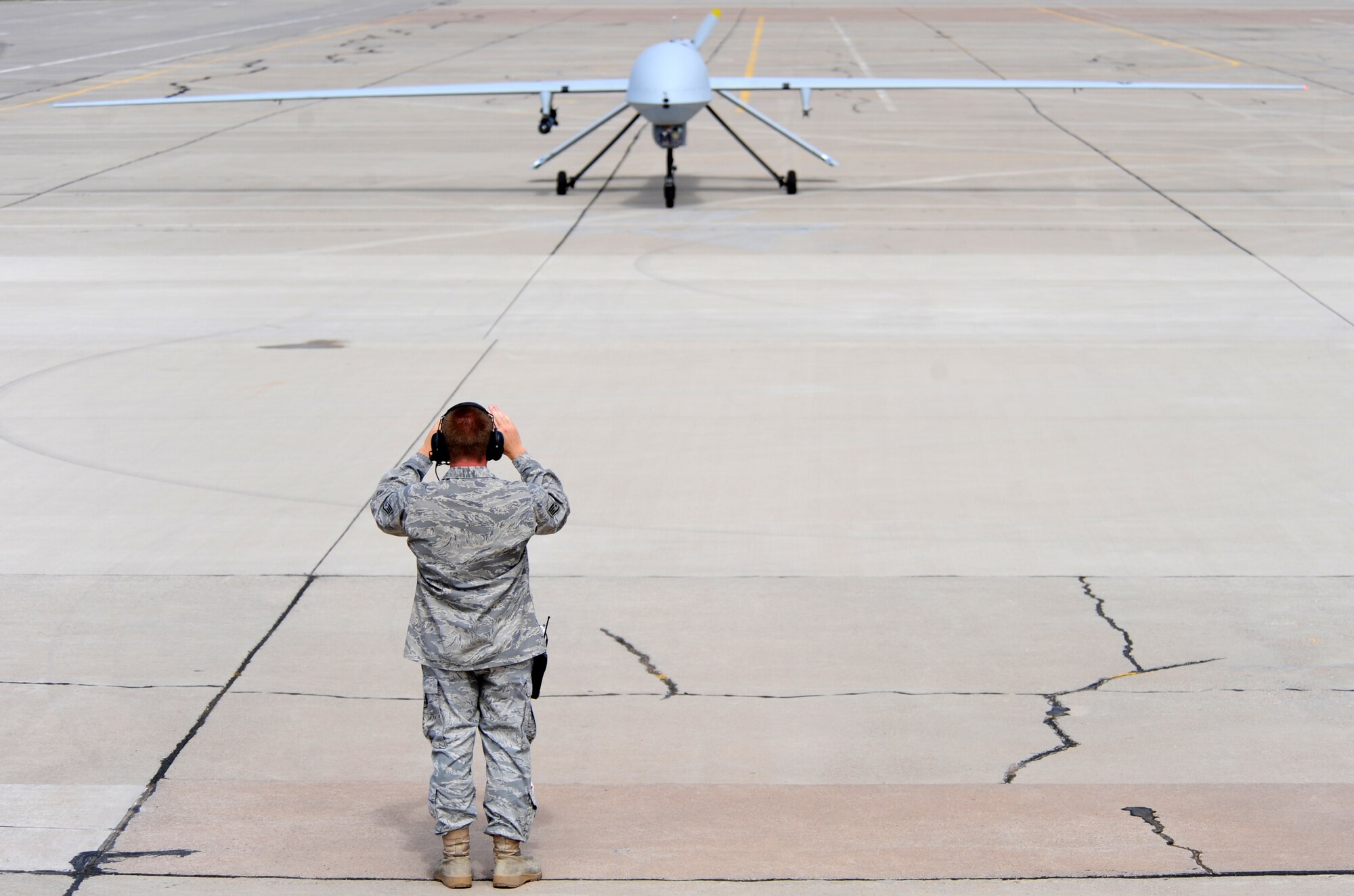 HOLLOMAN AIR FORCE BASE, N.M. -- Staff Sgt. Clifford Ferrero, 432nd Maintenance Group, Detachment 1, marshals in an MQ-1 Predator after it lands here Sept. 10 from its first official flight out of the base. With the flight, the 432nd Wing, Detachment 5, reached initial operational capacity at Holloman. (U.S. Air Force photo by Senior Airman Michael Means)