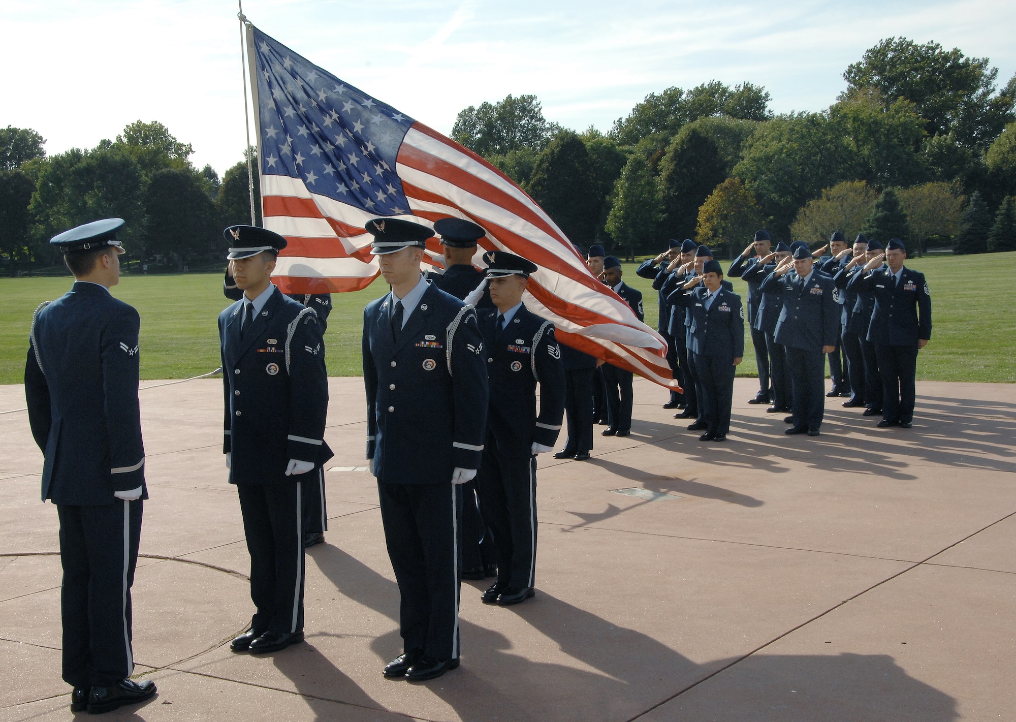 OFFUTT AIR FORCE BASE, Neb. - Offutt Honor Guard members raise the flag while base leadership salutes during a retreat ceremony held on the parade field in recognition of the 61st Air Force birthday. Offutt will host a celebration for the 62nd Air Force Birthday Sept. 18 at the Patriot Club. U.S. Air Force photo by Dana Heard.