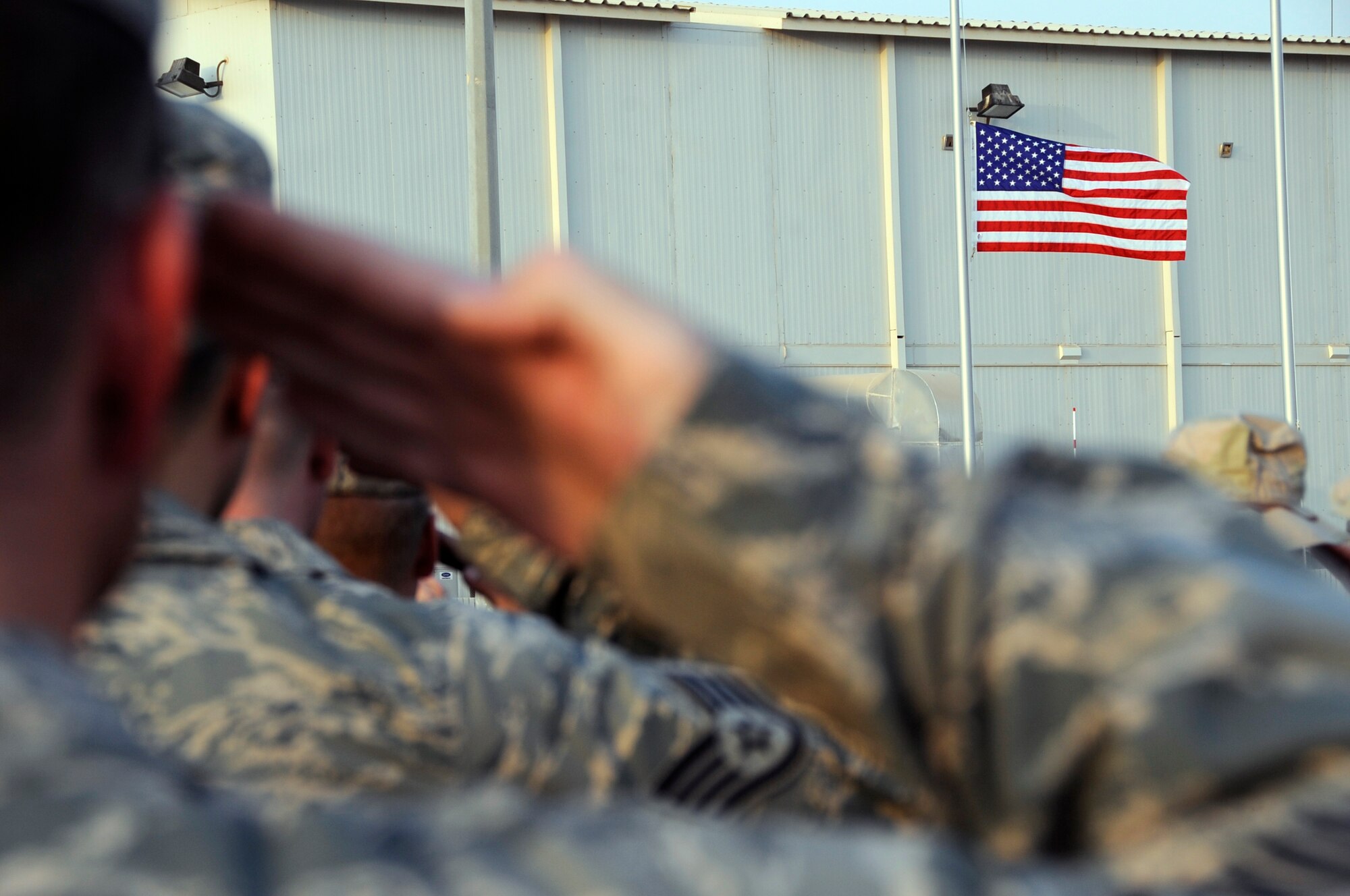 SOUTHWEST ASIA – Airmen and Soldiers salute the flag during a commemoration ceremony here on the eighth anniversary of Sept. 11, 2001. The memorial consists of a replica of the World Trade Center and three display cases: one dedicated to United Airlines Flight 93, one dedicated to the Pentagon, and one dedicated to the firefighters and policemen who gave the ultimate sacrifice Sept. 11, 2001. (U.S. Air Force photo/Senior Airman Stephen Linch)