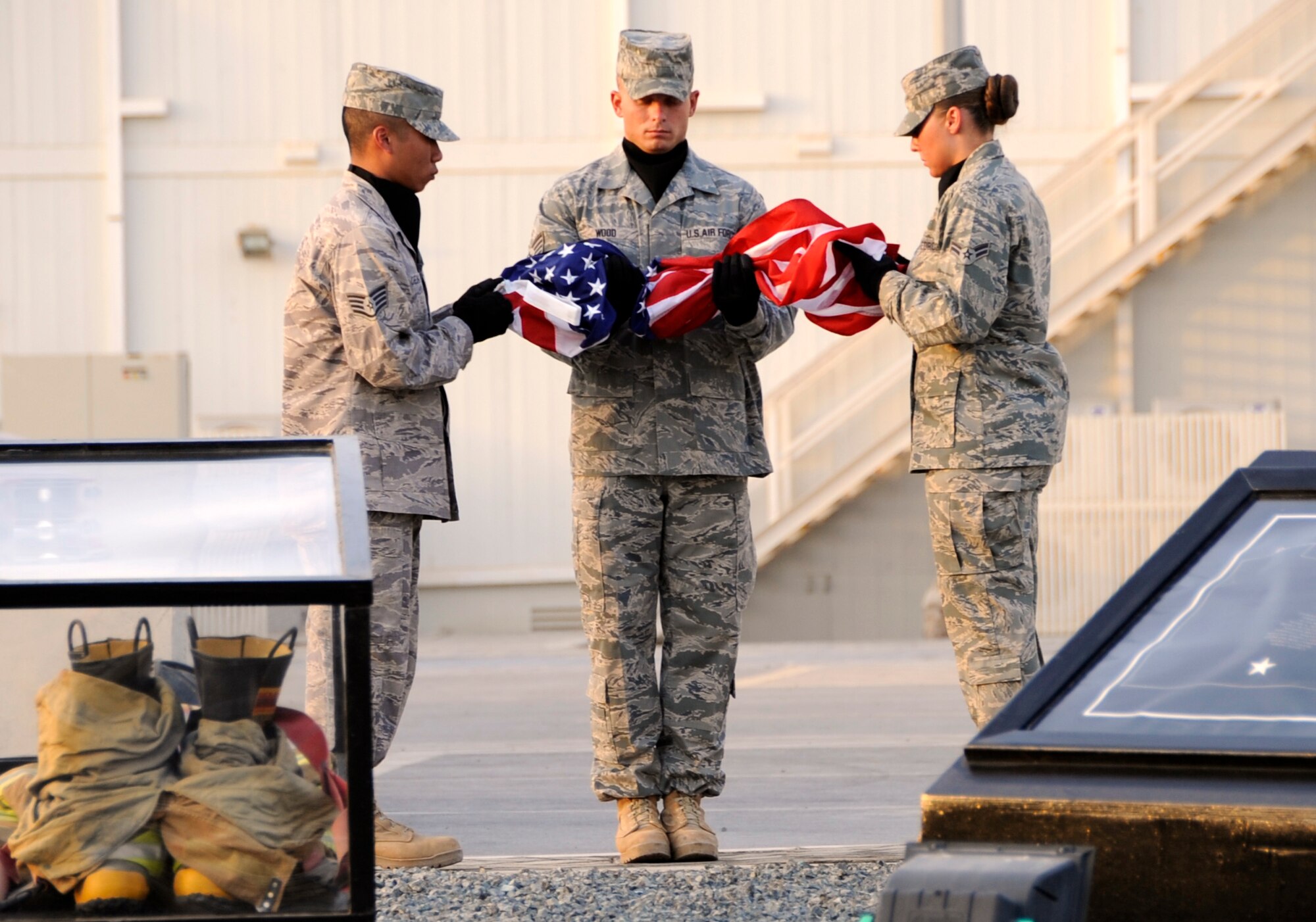 SOUTHWEST ASIA – 380th Air Expeditionary Wing Honor Guard members prepare to fold the flag during a commemoration ceremony here on the eighth anniversary of Sept. 11, 2001. The 380th AEW Honor Guard provides time honored customs and courtesies for official ceremonies. (U.S. Air Force photo/Senior Airman Stephen Linch)