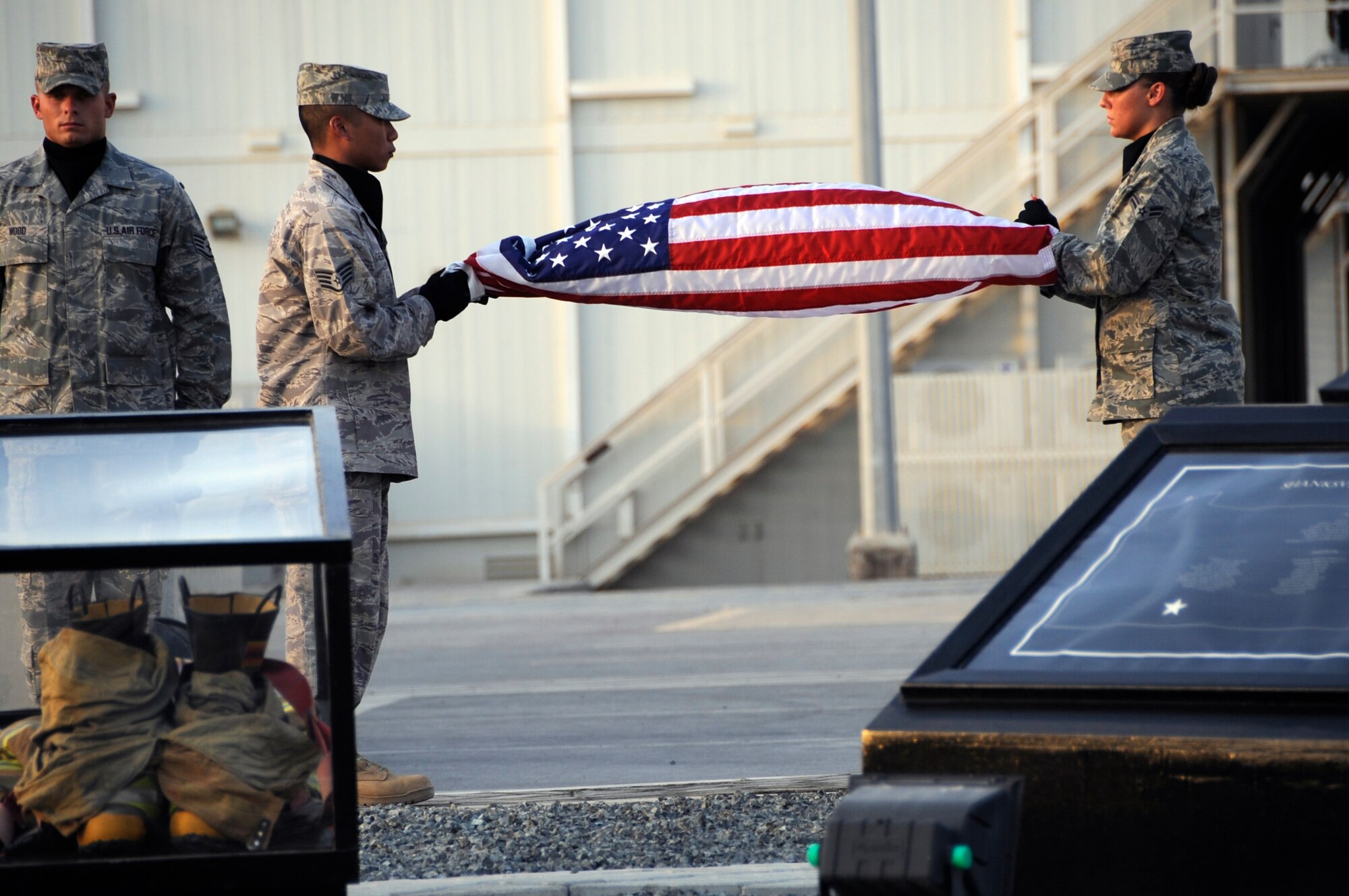 SOUTHWEST ASIA – 380th Air Expeditionary Wing Honor Guard members prepare to fold the flag during a commemoration ceremony here on the eighth anniversary of Sept. 11, 2001. More than 25 Airmen took it upon themselves to rebuild the 380th Air Expeditionary Wing's Sept. 11 memorial, which was dedicated Sept. 1, 2009.  (U.S. Air Force photo/Senior Airman Stephen Linch)