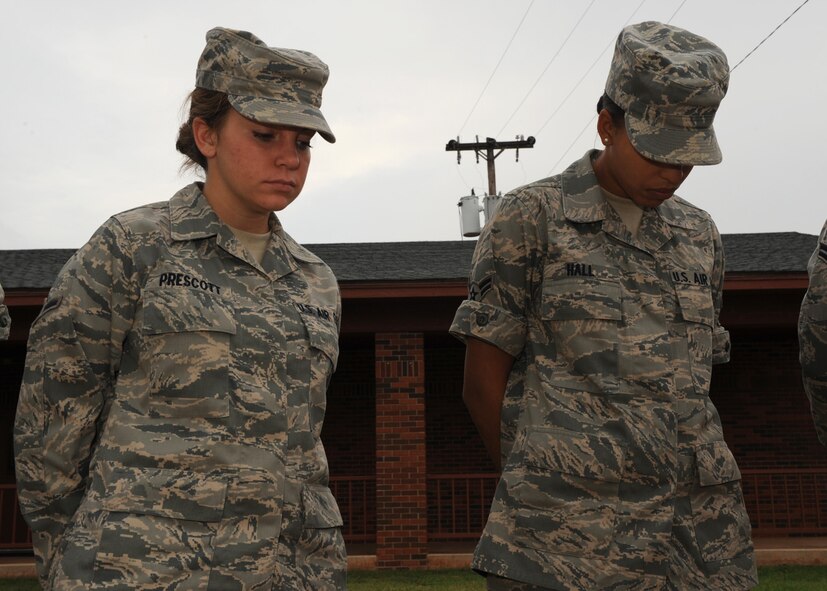 DYESS AIR FORCE BASE, Texas – Airman Brittney Prescott (left) and Airman First Class Shannon Hall, 7th Force Support Squadron, pray during the Sept. 11 remembrance ceremony here Sept. 11. The ceremony consisted of four bell chimes to represent the airline crashes and an additional two for the World Trade Center collapsing, followed by prayers for the nearly 3,000 victims and their families. (U.S Air Force photo by Senior Airman Jennifer Romig) 