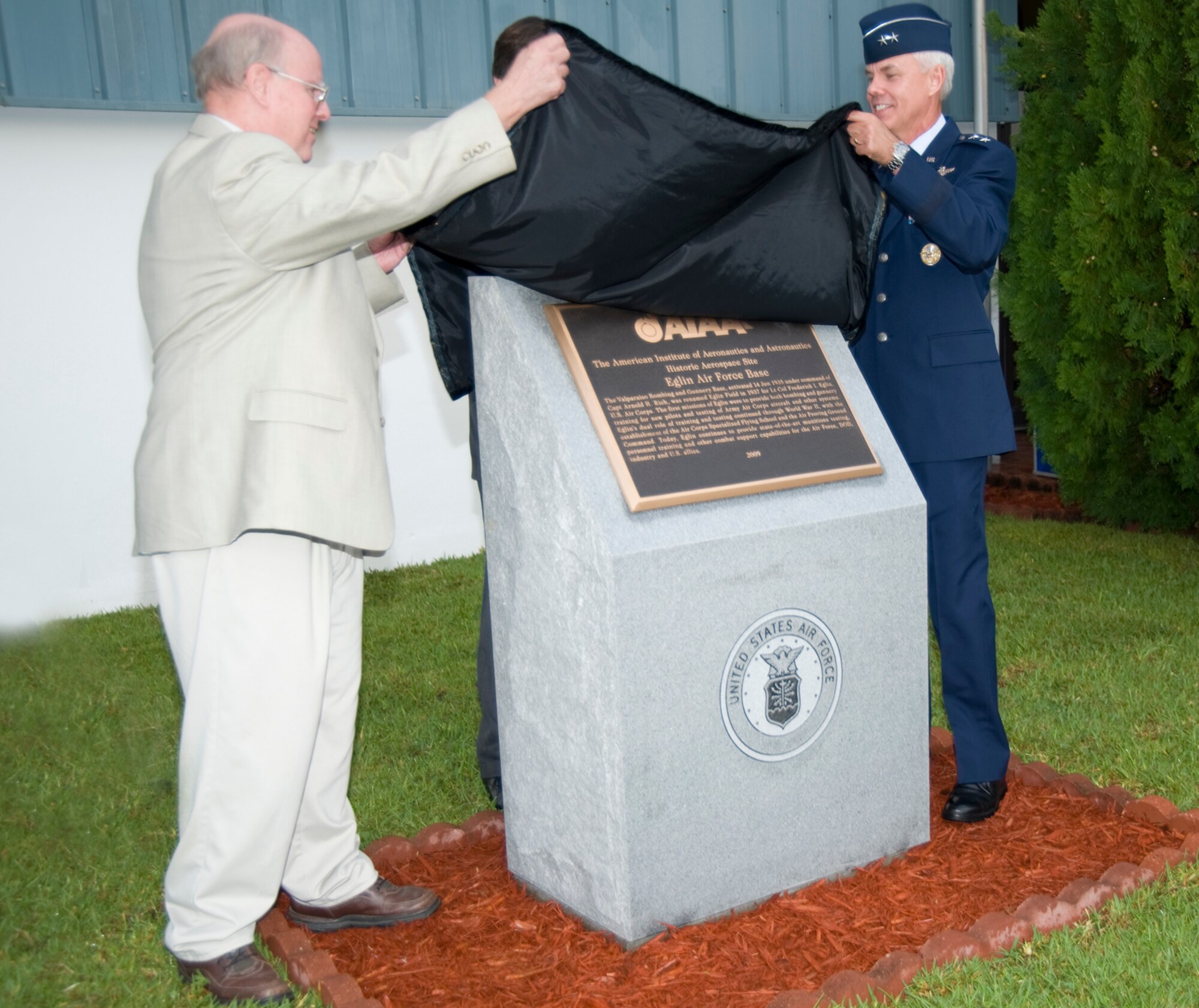 Dr. Richard Hallion, retired Air Force chief historian and Maj. Gen. C.R. Davis, Air Armament Center commander, unveil the bronze plaque from the American Institute of Aeronautics and Astronautics Sept. 10 at the Air Armament Museum.  AIAA named Eglin a historic aerospace site for 2009.  The plaque commemorated the occasion.  (U.S. Air Force photo/Debbie Haussermann)