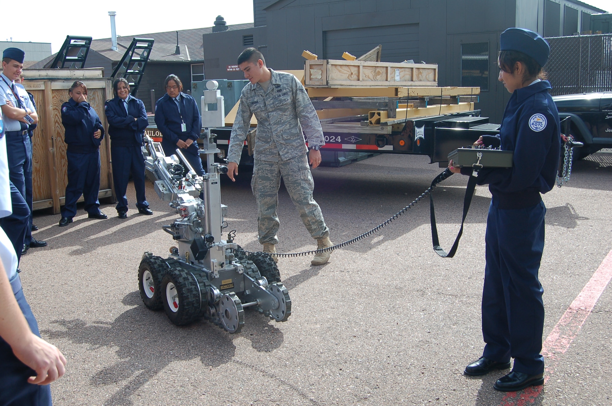 Mitchell High School Junior Reserve Officer Training Corps Cadet Karla Gallegos operates the F6A robot as Airmen First Class John Medina 21st Civil Engineer Squadron Explosive Ordnance Disposal Flight journeyman, conducts a demonstration at the 302nd Logistics Readiness Squadron building Sept. 10. Cadet Gallegos is in her first year in JROTC. (Air Force photo by Thea Skinner)