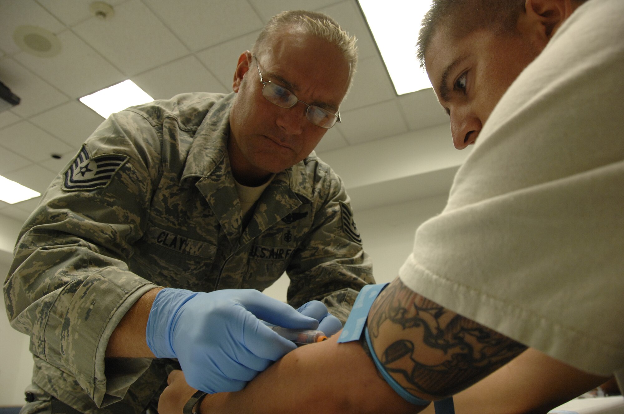 Tech. Sgt. Franklin Clay, a medical technician from the 129th Medical Group, draws blood from Staff Sgt. Ernesto Godinez, an HH-60G Pave Hawk helicopter crew chief,  during a routine redeployment inproccessing at Moffett Federal Airfield, Calif., Sept. 9.  Sergeant Godinez returned from a four-month deployment to Afghanistan. (Air National Guard photo by Tech. Sgt. Ray Aquino)