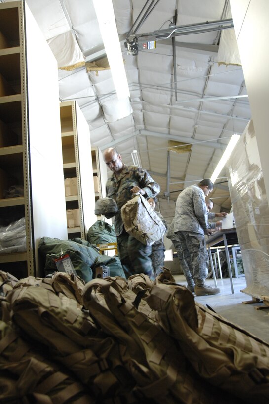 Tech. Sgt. Ben Baker, a supply technician from the 129th Logistics Readiness Squadron, gathers flak vest and helmets from airmen that returned home from an Afghanistan deployment during a routine inprocessing procedure at Moffett Federal Airfield, Calif., Sept. 9, 2009.  (Air National Guard photo by Tech. Sgt. Ray Aquino)