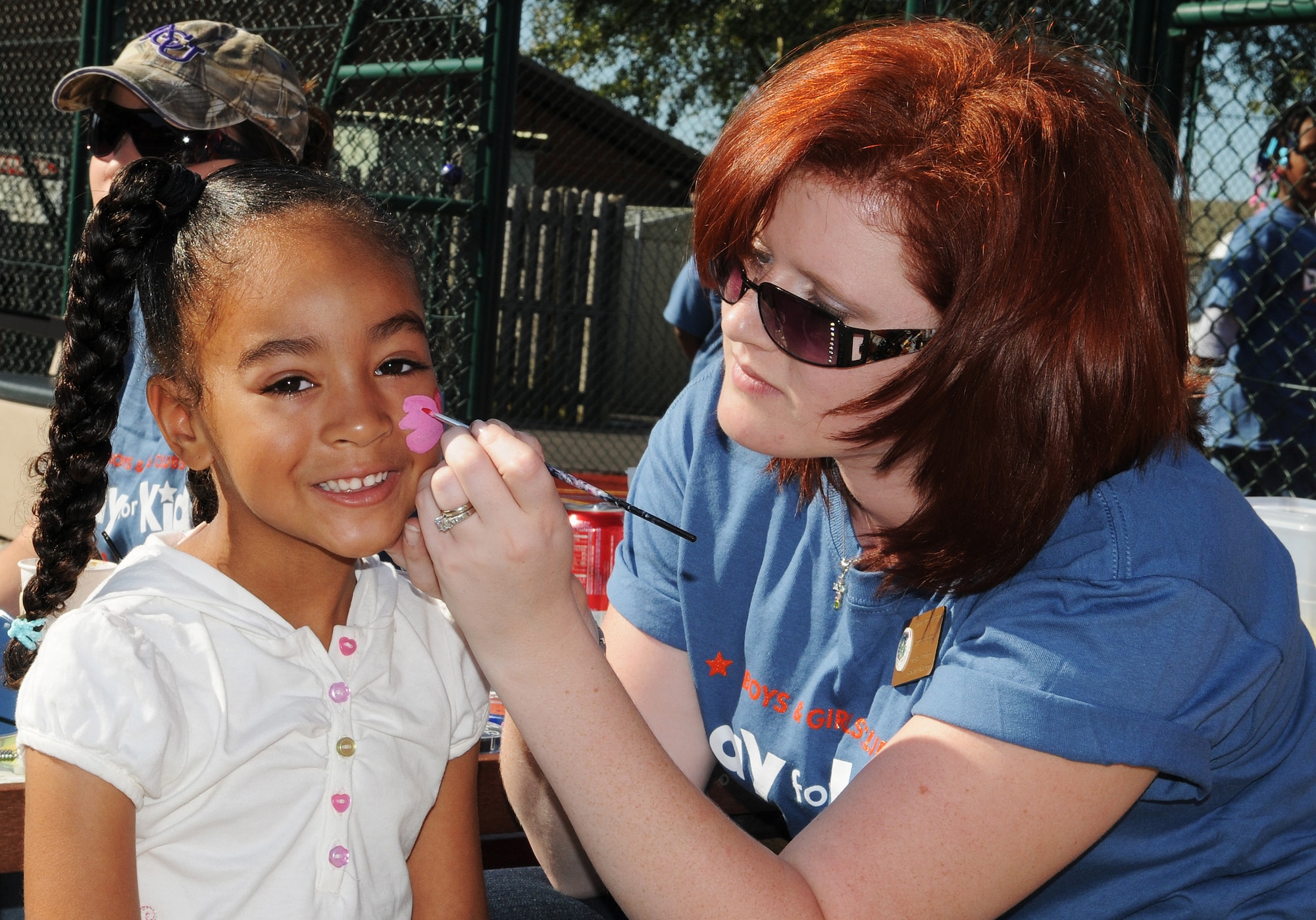 RAF MILDENHALL, England -- Alexys Guzman, 5, gets her face painted by Amands Woods, RAF Mildenhall Youth Center school age coordinator, at the Youth Center Sept. 12. Children from the base community and local area gathered for Boys and Girls Club Kids Day to play a variety of games. (U.S. Air Force photo/Senior Airman Thomas Trower) 