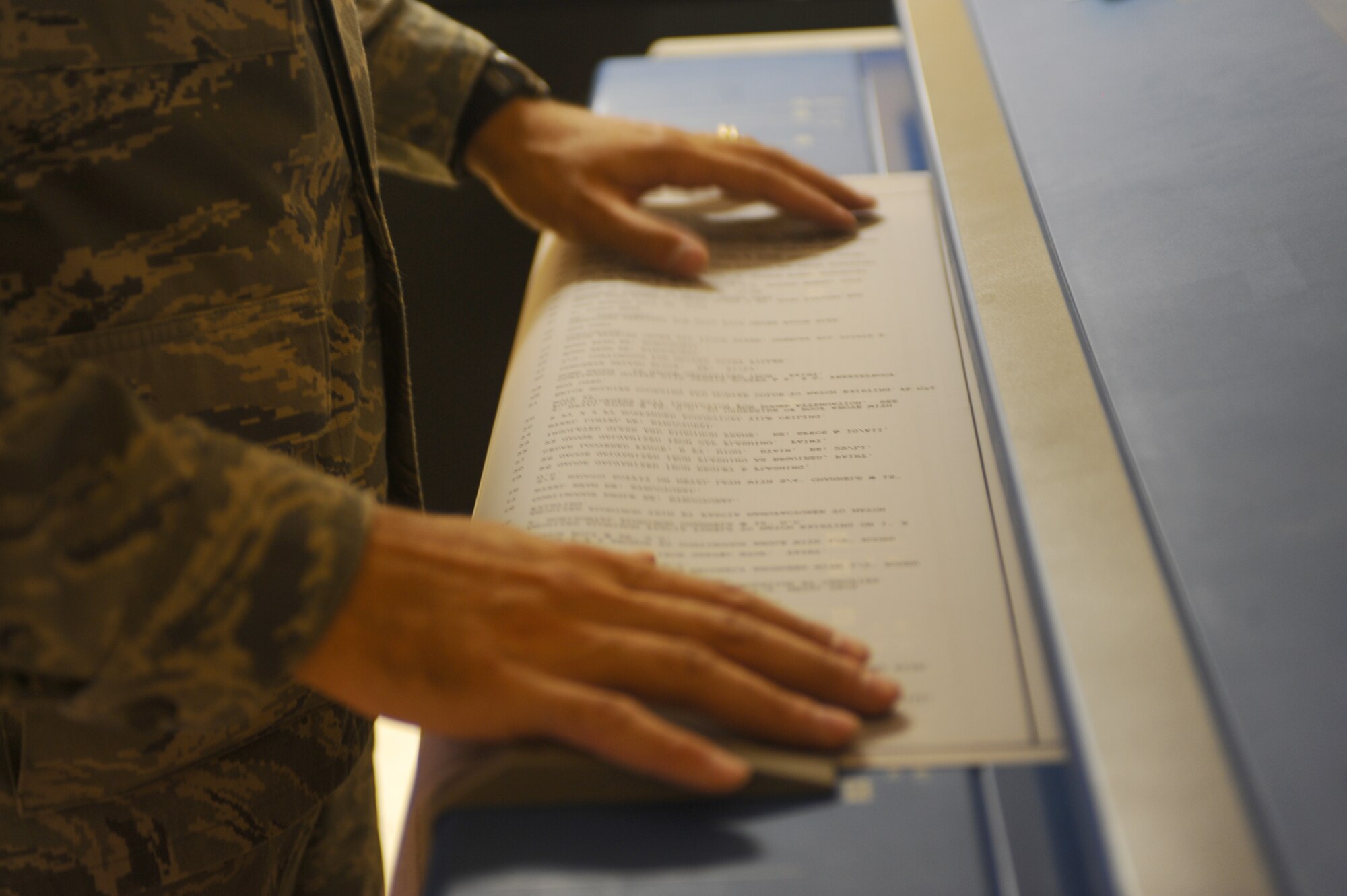 Airman 1st Class Alex Luebrecht, 28th Civil Engineer Squadron engineer technician, feeds a floor plan into a scanner here, Sept. 10. Airman Luebrecht scans the floor plan for easier future access. (U.S. Air Force photo/Senior Airman Kasey Zickmund)