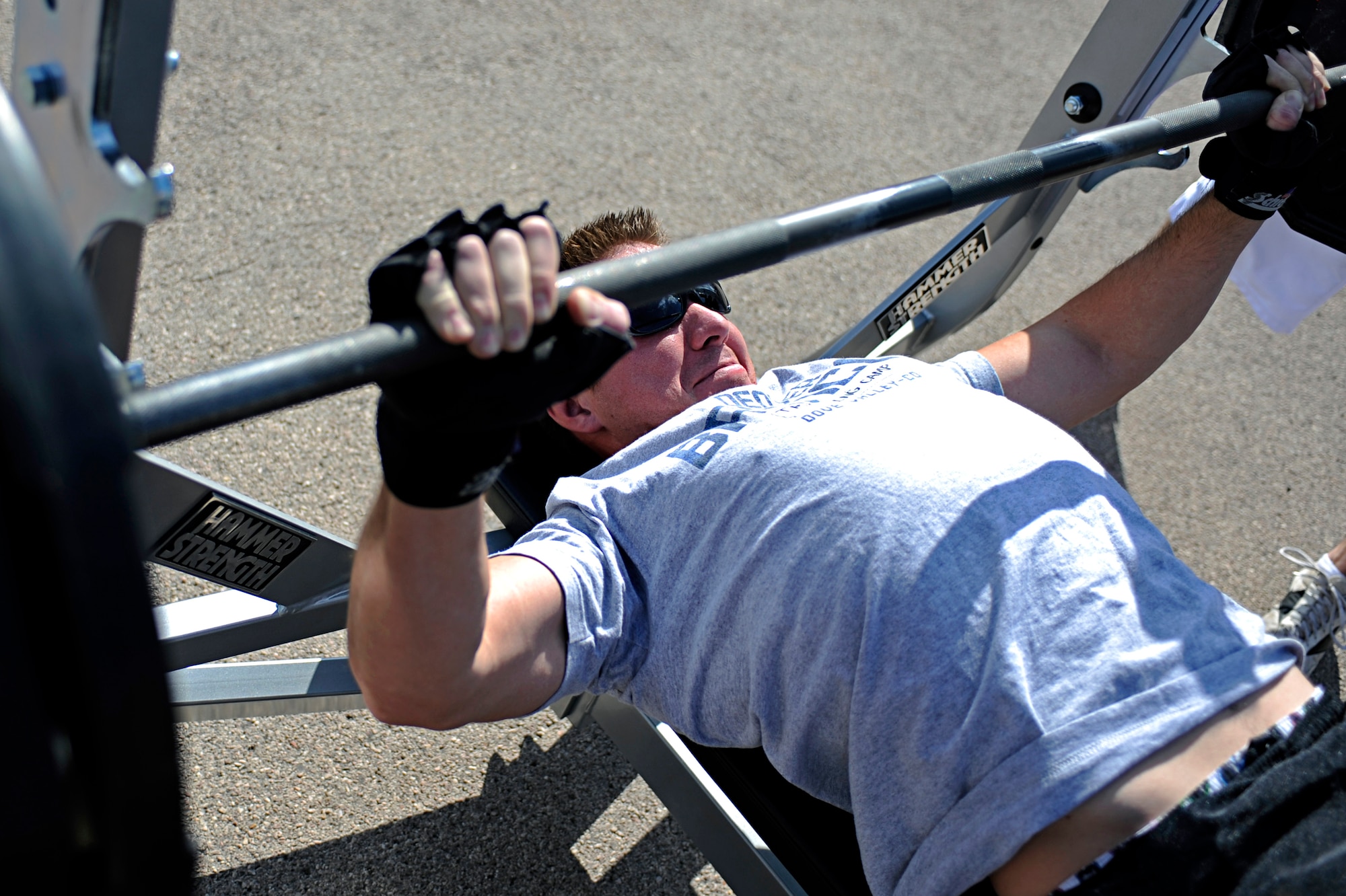 Senior Airman Ryan Logan, 28th Civil Engineer Squadron firefighter, bench presses 225 pounds during the football competition here, Sept. 10. During this event the participants had to complete as many repetitions as they could. The competition was open to the base populace to test various football skills. (U.S. Air Force photo/Airman 1st Class Matthew Flynn)
