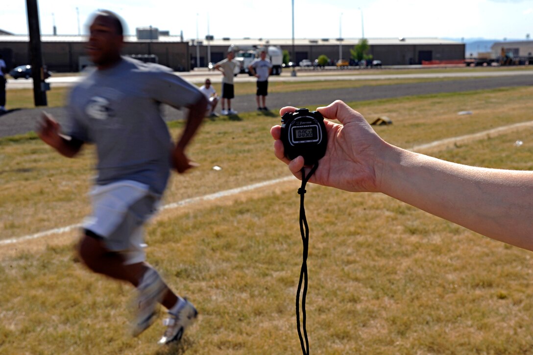 (Right) Tech. Sgt. Kathy Gatzke, 28th Force Support Squadron section chief, times 1st Lt. Overton Spence, 28th Comptroller and Contracting Squadron deputy flight chief, during a 40-yard dash here, Sept. 10. Lieutenant Spence competed against five other Airmen in a football competition open to the base populace to test the contestants’ various football skills. (U.S. Air Force photo/Airman 1st Class Matthew Flynn)