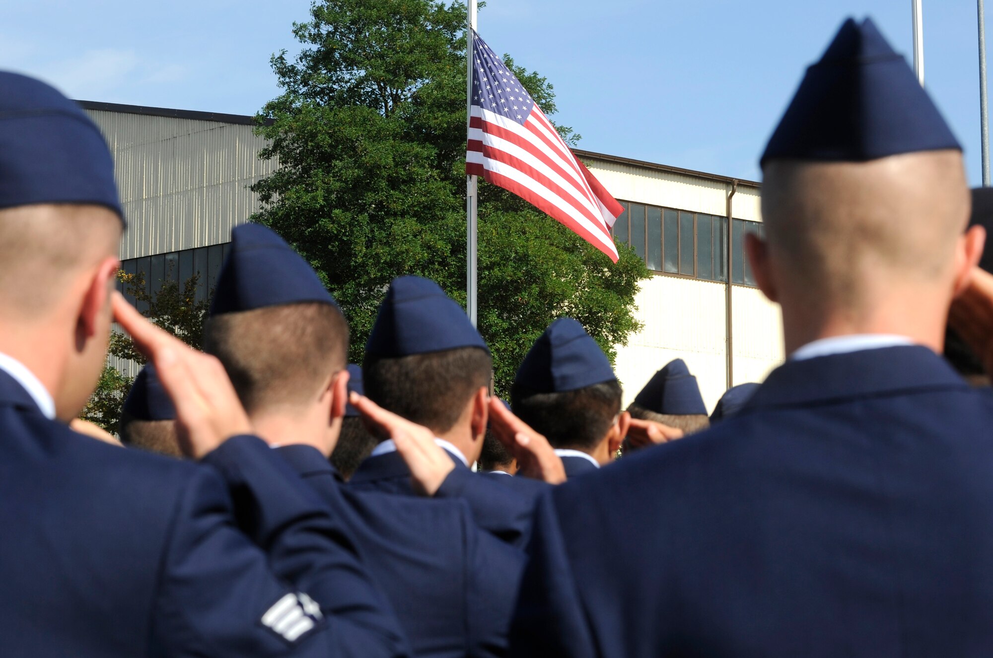 SPANGDAHLEM AIR BASE Germany – 52nd Fighter Wing Airmen stand in formation and salute the U.S. flag as it is lowered by the base honor guard during a retreat ceremony honoring the lives lost during 9/11 at the wing headquarters’ building..  About 200 52nd Fighter Wing and tenant unit members attended the 9/11 retreat ceremony put together by the First IV.  (U.S. Air Force photo/Master Sgt. Bill Gomez)