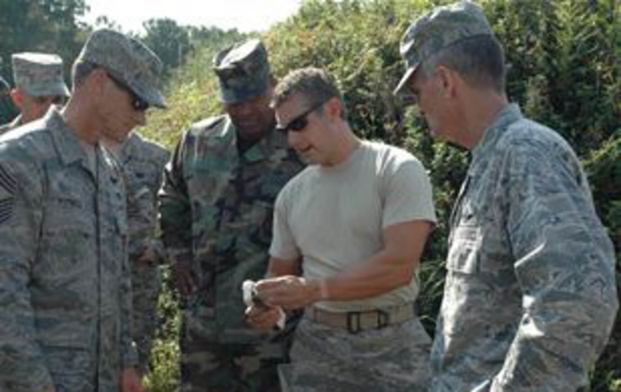 Major James Wood, commander of 315th Civil Engineering Flight, explains how explosive ordinance technicians use certain explosive materials to 315th Airlift Wing Commander Col. Steven Chapman and Command Chief Ben Futrell. Command leadership decided to participate in the required demolitions training to experience a few aspects of what it means to be an EOD technician. (U.S. Air Force photo by Senior Airman Dani Pacheco)