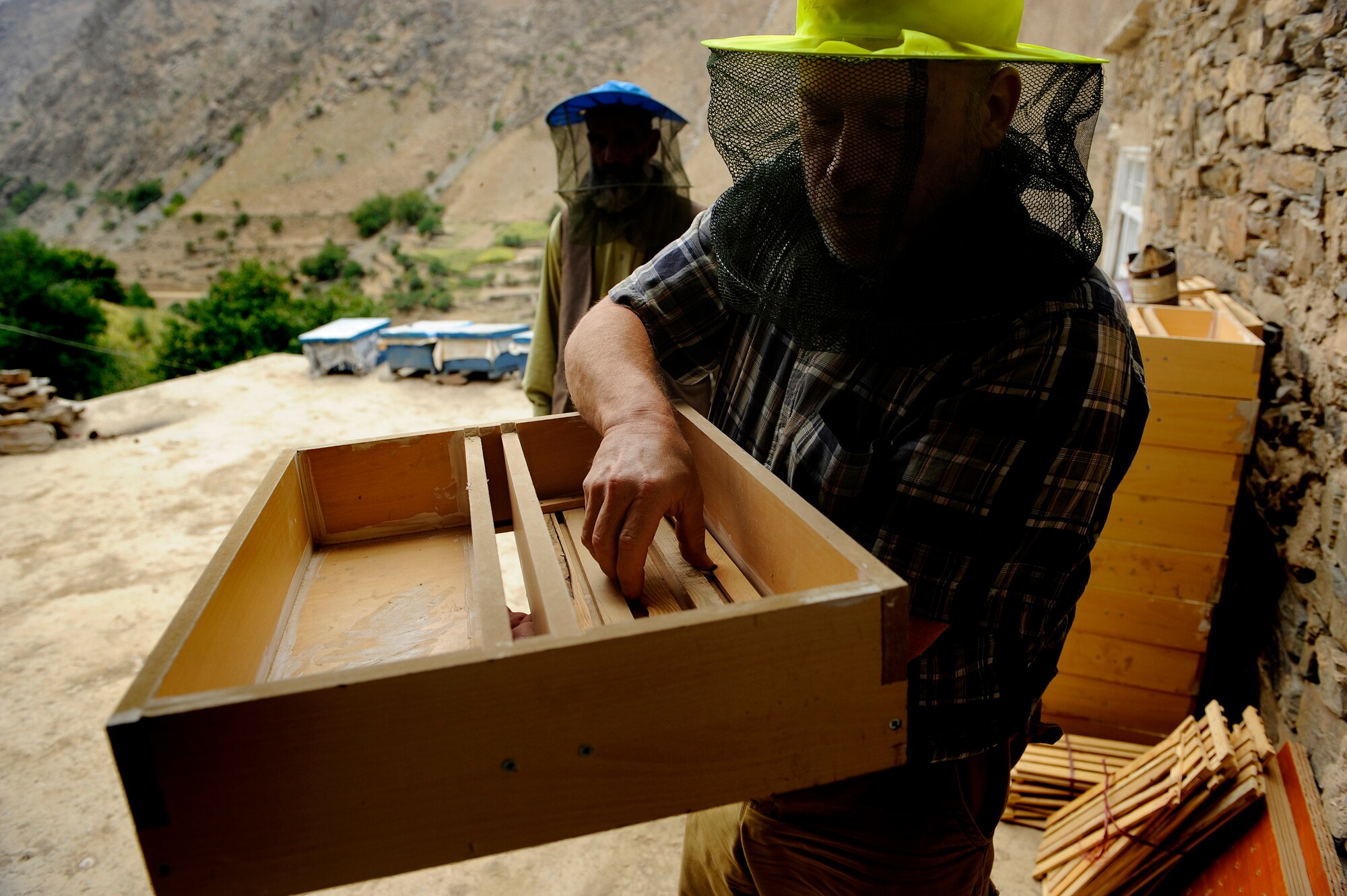 BAGRAM AIRFIELD, Afghanistan - Greg Schlenz, a U.S. Department of Agriculture representative to the Panjshir Provincial Reconstruction Team, inspects a hive-top feeder, Sept. 7. The feeders are filled with sugar syrup and placed on top of the hives during the winter, so the bees will have enough food to survive. (U.S. Air Force photo/Staff Sgt. Mike Keller)