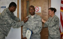 SEYMOUR JOHNSON AIR FORCE BASE, N.C. -- Air Force Reservist TJ Brown III, (center), is promoted to the rank of master sergeant during the September unit training assembly. Capt. Terrence Spikes (left) and Master Sgt. Jennifer Conway (right) do the honor of ?tacking on? Sgt. Brown?s new stripes. All three reservists work with the 916th Communications Squadron. U.S. Air Force photo by MSgt. Shane Lynch, 916th CS.
