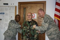 SEYMOUR JOHNSON AIR FORCE BASE, N.C. -- Air Force Reservist Michael Ciancio, (center), is promoted to the rank of technical sergeant during the September unit training assembly. Newly promoted Master Sgt. TJ Brown III (left) and Master Sgt. Matt Jamison (right) do the honor of ?tacking on? Sgt. Ciancio?s new stripes. All three reservists work with the 916th Communications Squadron. U.S. Air Force photo by MSgt. Shane Lynch, 916th CS