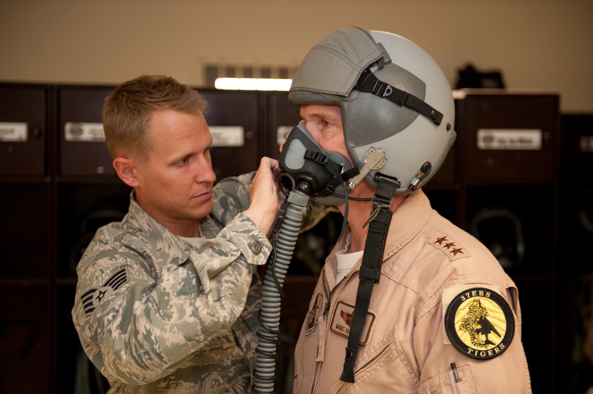 Left, U.S. Air Force Staff Sgt. Charles Crooks, 379th Expeditionary Operations Support Squadron aircrew flight equipment journeyman, assists U.S. Air Forces Central Command Commander Lt. Gen. Mike Hostage with the fitting of his aircrew survival equipment, Sept. 9, in Southwest Asia. General Hostage is a command pilot with more than 4,000 flying hours. As the Air Component Commander for U.S. Central Command, he is responsible for developing contingency plans and conducting air operations in a 20-nation area of responsibility covering Central and Southwest Asia. (U.S. Air Force photo/Staff Sgt. Robert Barney/RELEASED) 
