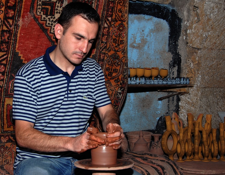 A Turkish artisan demonstrates how to sculpt a flower pot on a kick-style pottery wheel in an Avanos, Turkey, pottery shop. The town of Avanos is known for its terra-cotta products. Inside, the shop shelves were filled with clay jars, hand painted plates, wine carafes and goblets. (U.S. Air Force photo/Staff Sgt. Lauren Padden)