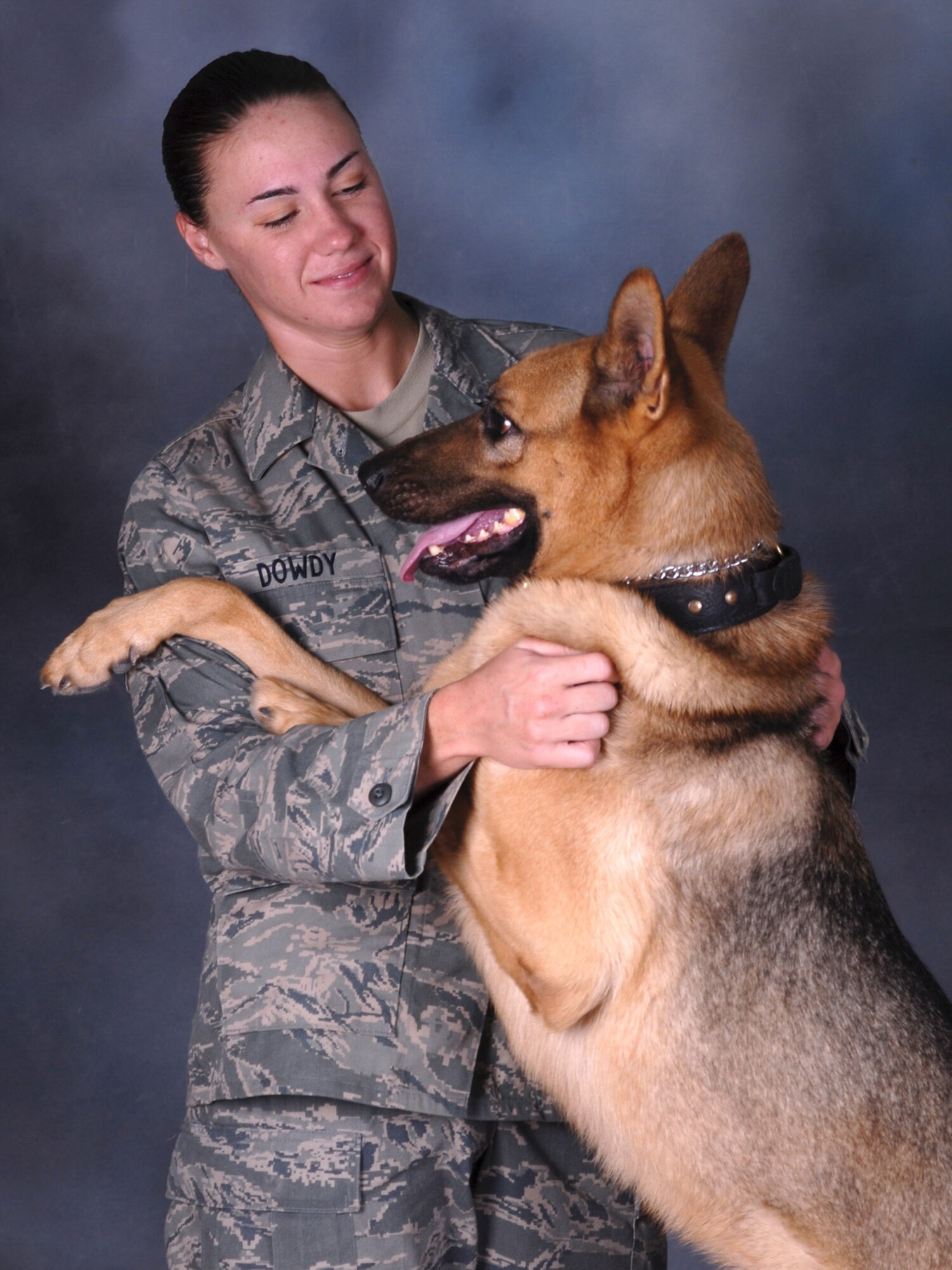Senior Airman Carrie Dowdy, 379th Expeditionary Security Forces Squadron military working dog handler, and her partner, Ciro, a seven-year-old German Shepherd, pose for a portrait. Ciro is trained in both explosive detection and patrol. Airman Dowdy and Ciro are deployed from Tyndall Air Force Base, Fla. in support of Operations Iraqi and Enduring Freedom. (U.S. Air Force Photo/Tech Sgt. Jason W. Edwards)