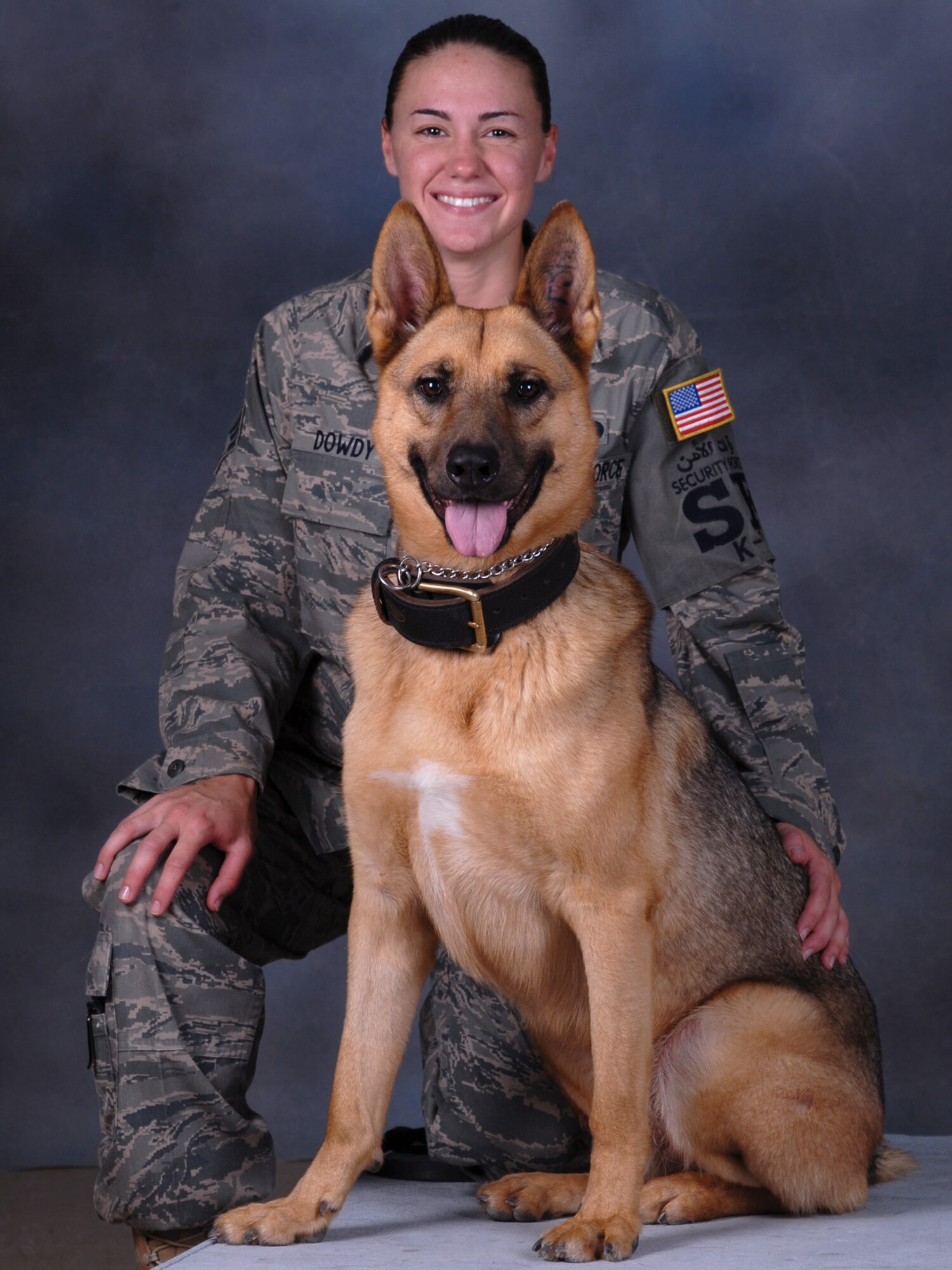 Senior Airman Carrie Dowdy, 379th Expeditionary Security Forces Squadron military working dog handler, and her partner, Ciro, a seven-year-old German Shepherd, pose for a portrait. Ciro is trained in both explosive detection and patrol. Airman Dowdy and Ciro are deployed from Tyndall Air Force Base, Fla. in support of Operations Iraqi and Enduring Freedom. (U.S. Air Force Photo/Tech Sgt. Jason W. Edwards)
