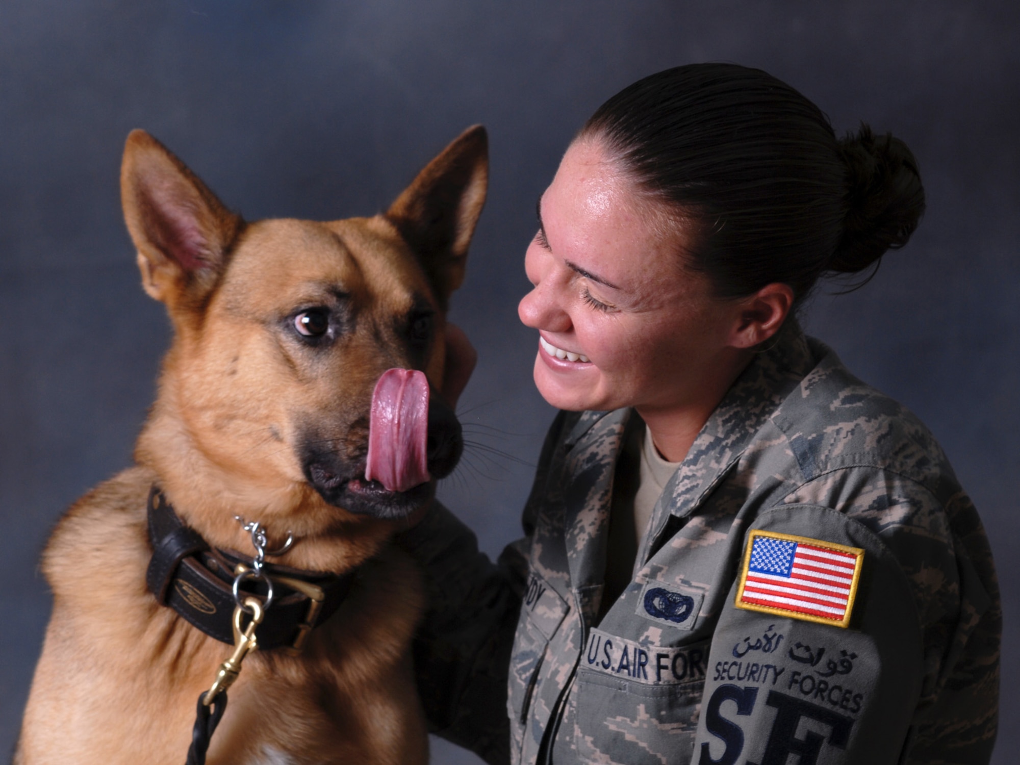 Senior Airman Carrie Dowdy, 379th Expeditionary Security Forces Squadron military working dog handler, and her partner, Ciro, a seven-year-old German Shepherd, pose for a portrait. Ciro is trained in both explosive detection and patrol. Airman Dowdy and Ciro are deployed from Tyndall Air Force Base, Fla. in support of Operations Iraqi and Enduring Freedom. (U.S. Air Force Photo/Tech Sgt. Jason W. Edwards)