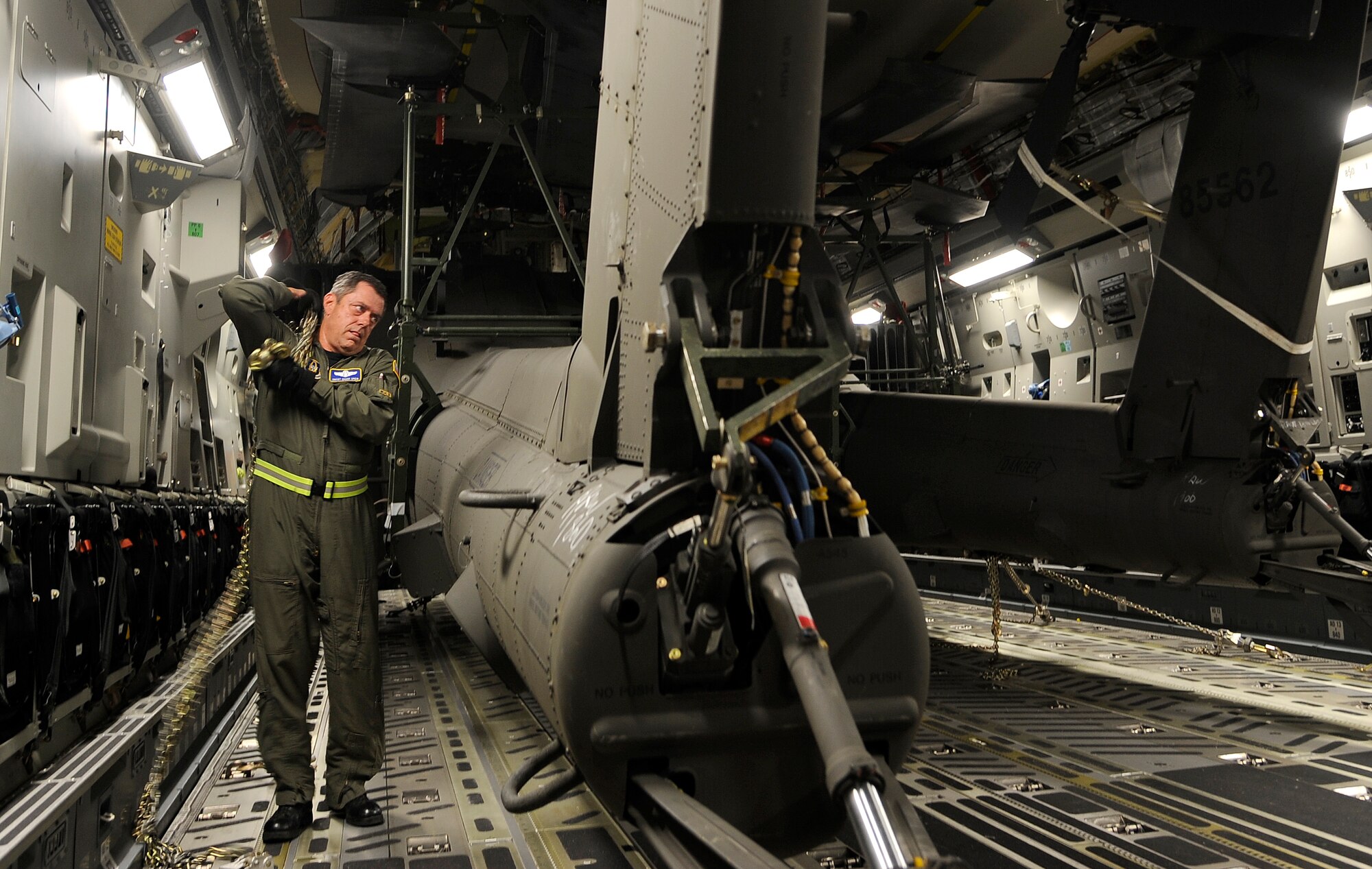 Senior Master Sgt. Chuck Speir removes the chains securing one of three AH-64D Apache Longbows to the floor of a C-17 Globemaster III, Sept. 9, at Osan Air Base. These helicopters are the first of 24 the Army is swapping for the newer block II model over the next four months. Sergeant Speir is a loadmaster with the 301st Airlift Squadron, Travis Air Force Base, Calif. (U.S. Air Force photo/Staff Sgt. Brian Ferguson)


