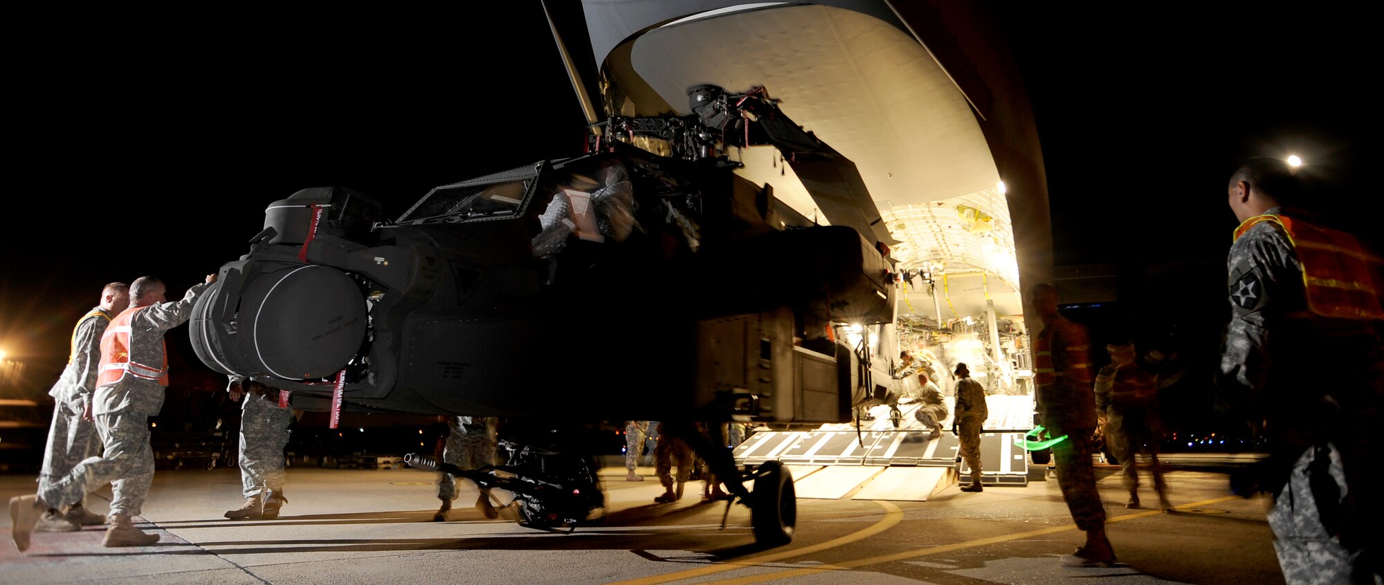 Army soldiers from the 2nd Combat Aviation Brigade, Camp Humphreys, Republic of Korea, off-loading one of three new AH-64D Apache Longbows from a C-17 Globemaster III, Sept. 9, at Osan Air Base. These helicopters are the first of 24 the Army is swapping for the newer block II model over the next four months.  (U.S. Air Force photo/Staff Sgt. Brian Ferguson)

