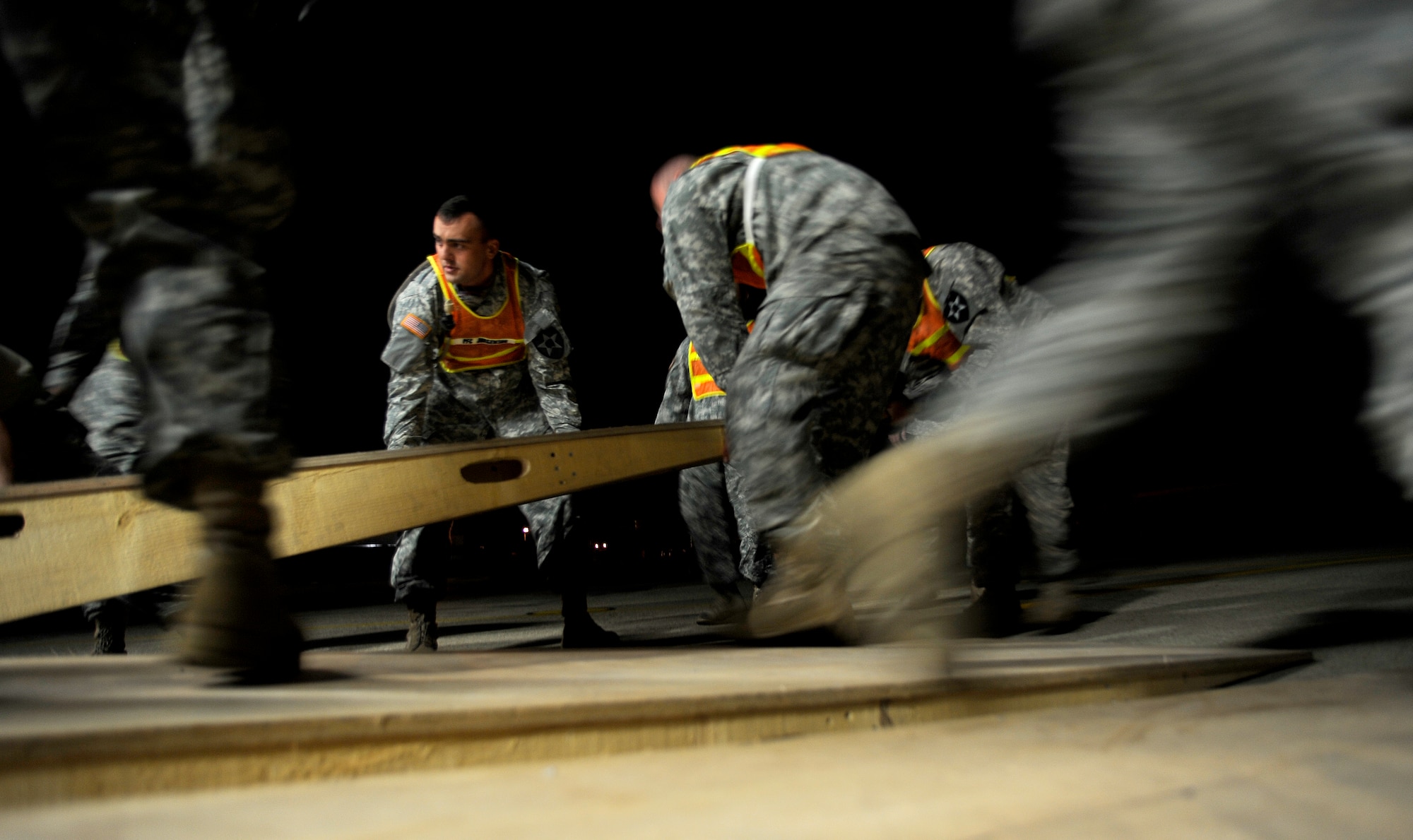 Army soldiers from the 2nd Combat Aviation Brigade, Camp Humphreys, Republic of Korea, position a ramp before off-loading three new AH-64D Apache Longbows from a C-17 Globemaster III, Sept. 9, at Osan Air Base. These helicopters are the first of 24 the Army is swapping for the newer block II model over the next four months.  (U.S. Air Force photo/Staff Sgt. Brian Ferguson)

