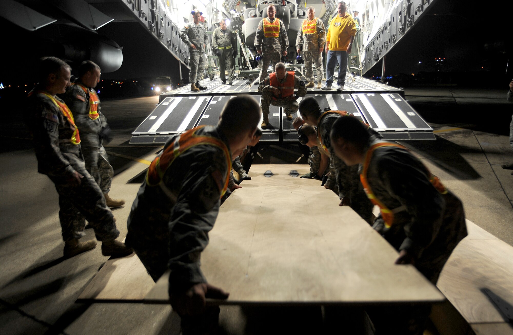 Army soldiers from the 2nd Combat Aviation Brigade, Camp Humphreys, Republic of Korea, position a ramp before off-loading three new AH-64D Apache Longbows from a C-17 Globemaster III, Sept. 9, at Osan Air Base. These helicopters are the first of 24 the Army is swapping for the newer block II model over the next four months.  (U.S. Air Force photo/Staff Sgt. Brian Ferguson)


