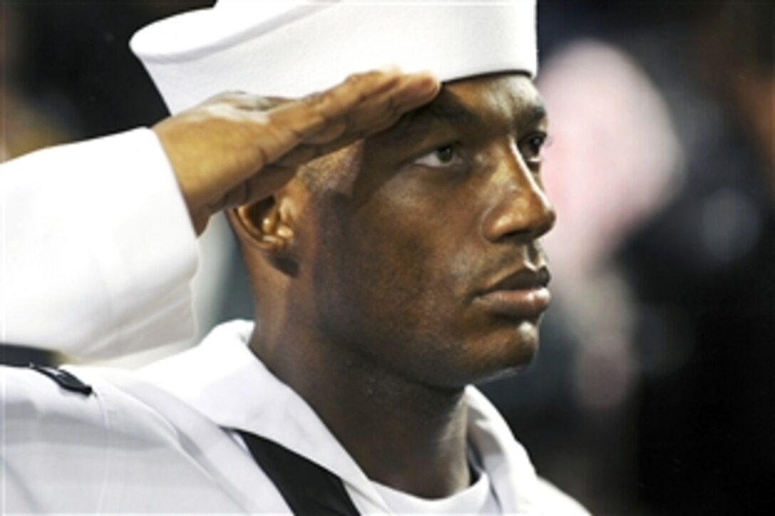 U.S. Navy Chief Hakim Bristow salutes during the national anthem during a pre-game ceremony at Yankee Stadium, New York, Sept. 11, 2009. The New York Yankees organization recognized sailors assigned to the amphibious transport dock ship New York before the game. The New York, which has 7.5 tons of World Trade Center steel in her bow, is scheduled to be commissioned Nov. 7 in New York.