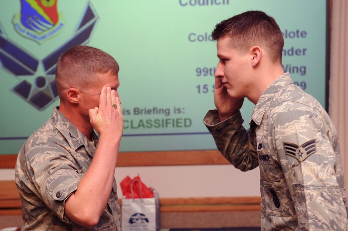 NELLIS AIR FORCE BASE Nev.,-- Col. Dave Belote, 99th Air Base Wing commander, presents the Defender of the Quarter Award to Senior Airman William Dale, an armorer with the 99th Security Forces Squadron, at the Civilian Military Council Luncheon, Sept. 15. Airman Dale was recognized by both the Las Vegas and Nellis community. Held every quarter, the Civilian Military Council Luncheon is an open forum where Las Vegas and Nellis leaders gather to discuss up and coming topics and helps foster ties with our local communities. (U.S. Air Force photo by Airman 1st Class Brett Clashman) 