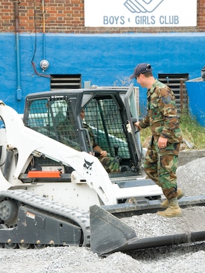 Technical Sgt Mike Stanley, standing, and Master Sgt Kevin Link took a break from their duties at the 167th Airlift Wing in Martinsburg, West Virginia to assist with gravelling a parking lot at the Martinsburg Boys and Girls Club, part of the United Way's Day of Caring activities, Tuesday, September 15, 2009. (U.S. Air Force photo by Master Sgt Emily Beightol-Deyerle)