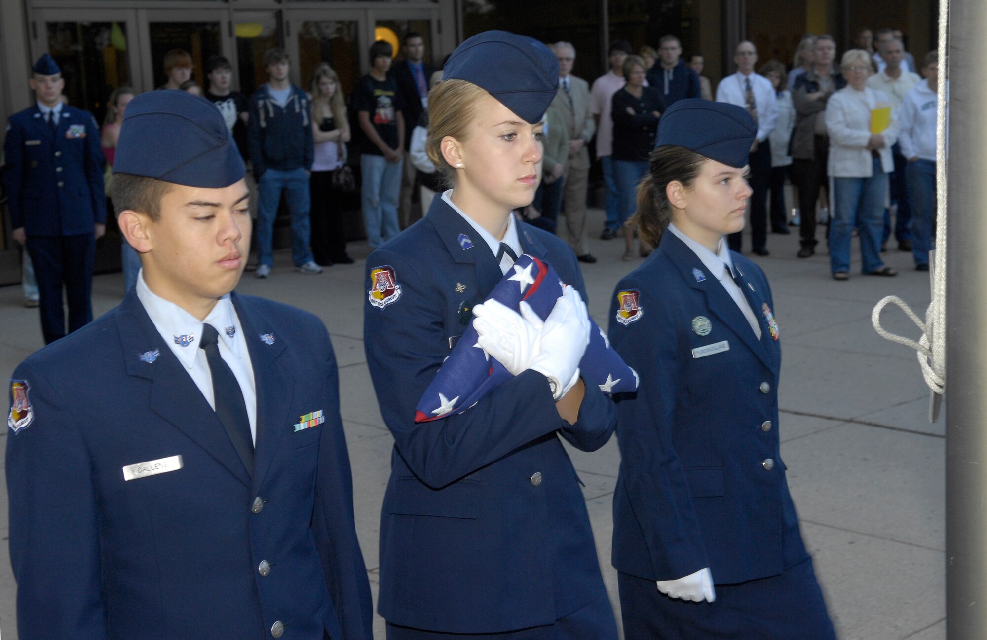 MINOT, N.D. -- Cadet Major Elizabeth Stahl, Cadet Corps squadron ND20021 commander, leads Cadets Airman 1st Class Dan Callens and Capt. Sara Fundingsland, during the flag detail for a ceremony remembering the lives lost and commemorating the heroism and comradery in the Sept. 11, 2001 terrorist attacks at the Magic City Campus High School Sept. 11 here. (U.S. Air Force Photo by Airman 1st Class Benjamin Stratton)