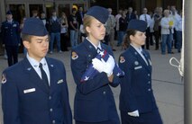 MINOT, N.D. -- Cadet Major Elizabeth Stahl, Cadet Corps squadron ND20021 commander, leads Cadets Airman 1st Class Dan Callens and Capt. Sara Fundingsland, during the flag detail for a ceremony remembering the lives lost and commemorating the heroism and comradery in the Sept. 11, 2001 terrorist attacks at the Magic City Campus High School Sept. 11 here. (U.S. Air Force Photo by Airman 1st Class Benjamin Stratton)