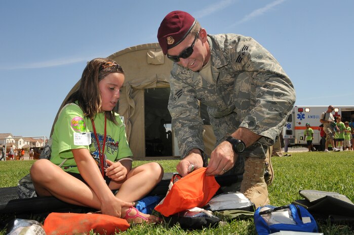 NELLIS AIR FORCE BASE, Nev.,--  Senior Airman Bowyer White, a 58th Rescue Squadron pararescueman, shows Freedom Martens the different medical gear typically carried in a standard medical pack during the Kids Understanding of Deployment Operations (KUDO) program, Sep. 12. KUDO is a mock deployment for military children. Hundreds of military children participated in KUDO. (U.S. Air Force photo by Tech. Sgt. Michael R. Holzworth)