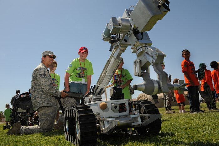 NELLIS AIR FORCE BASE Nev.,-- Staff Sgt. David Kuric of the 99th Civil Engineers Squadron, Explosive Ordinance Disposal section demonstrated how to operate a bomb robot for James Litwinski during a mock deployment in support of the Kids Understanding of Deployment Operations program better known as Operation KUDO's.  Hundreds of military children participated in the Operation KUDO's deployment at Nellis Air Force Base Sept. 12.
(U.S. Air Force photo by Tech. Sgt. Michael R. Holzworth)
