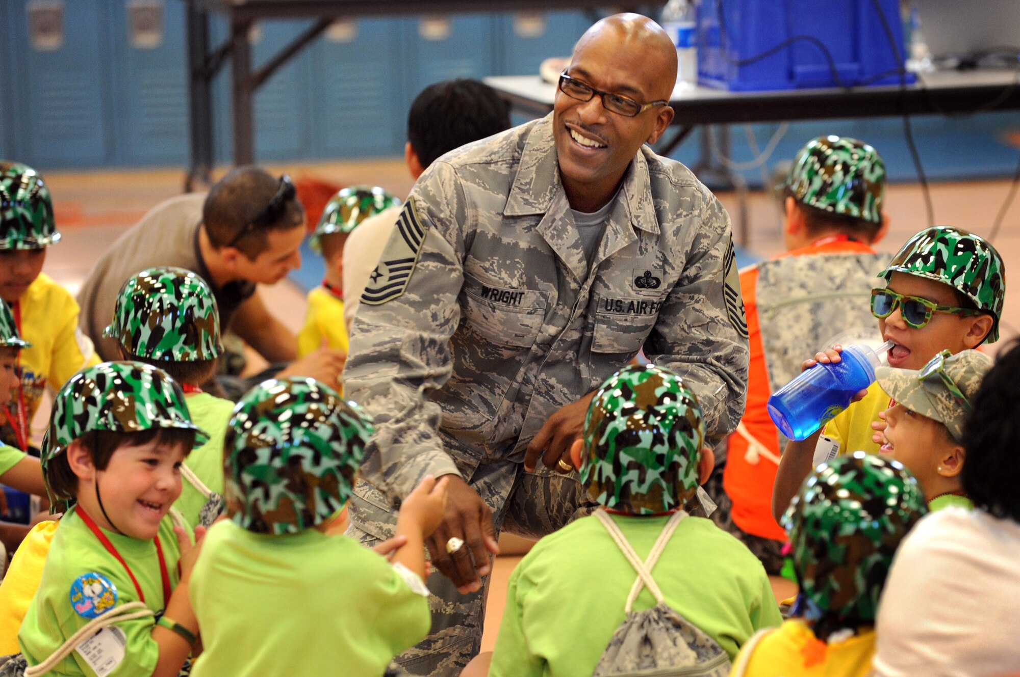 NELLIS AIR FORCE BASE, Nev.-- Chief Master Sgt. Brian Wright, 99th Force Support Squadron superintendent, shares a laugh with children before their participation in Kids Understanding of Deployment Operations (Operation KUDOS), a  mock deployment for Nellis children to help them understand and experience the deployment process.  Hundreds of military children participated in Operation KUDOS at the Nellis Youth Center, Sept. 12.   (U.S. Air Force photo by Tech. Sgt. Michael R. Holzworth)

