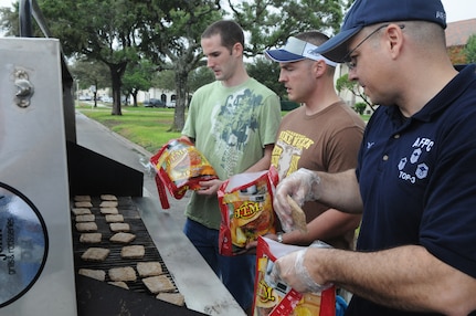 Randolph AFB, TX, 11 Sep 09:  Jeff Gilbert (Left), Brad Bryant (center), and Angel Espinosa, Air Force Personnel Center, cook hamburgers for the hungry people attending the Patriots Day celebrations.  (U.S. Air Force photo by Rich McFadden)